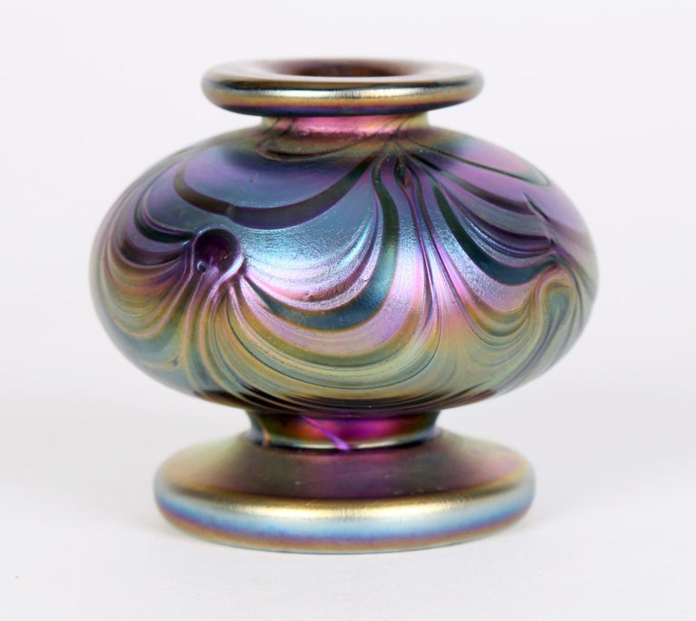 An exceptional quality Art Nouveau miniature iridescent glass vase, possibly Loetz and dating from the early 20th century. This heavily made amethyst glass vase is exquisitely decorated with golden iridescent trailed peacock feather patterning in