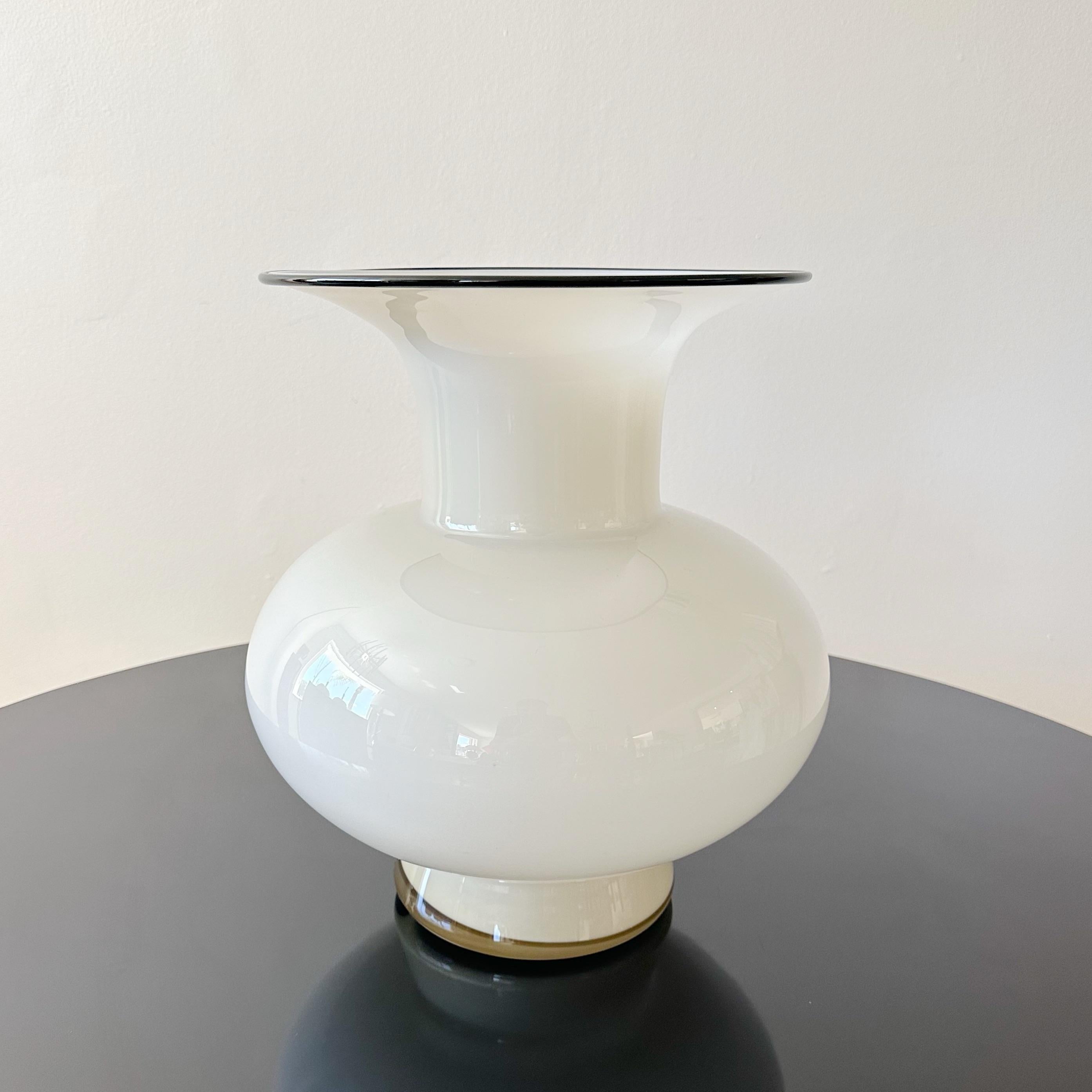 Loetz Bohemian vase crafted by Michael Powolny during the 1920s. This piece from the early 20th century showcases an exceptional size uncommon for Powolny. Adorned in a cream hue, accentuated by an applied black glass rim. The opening of the vase is