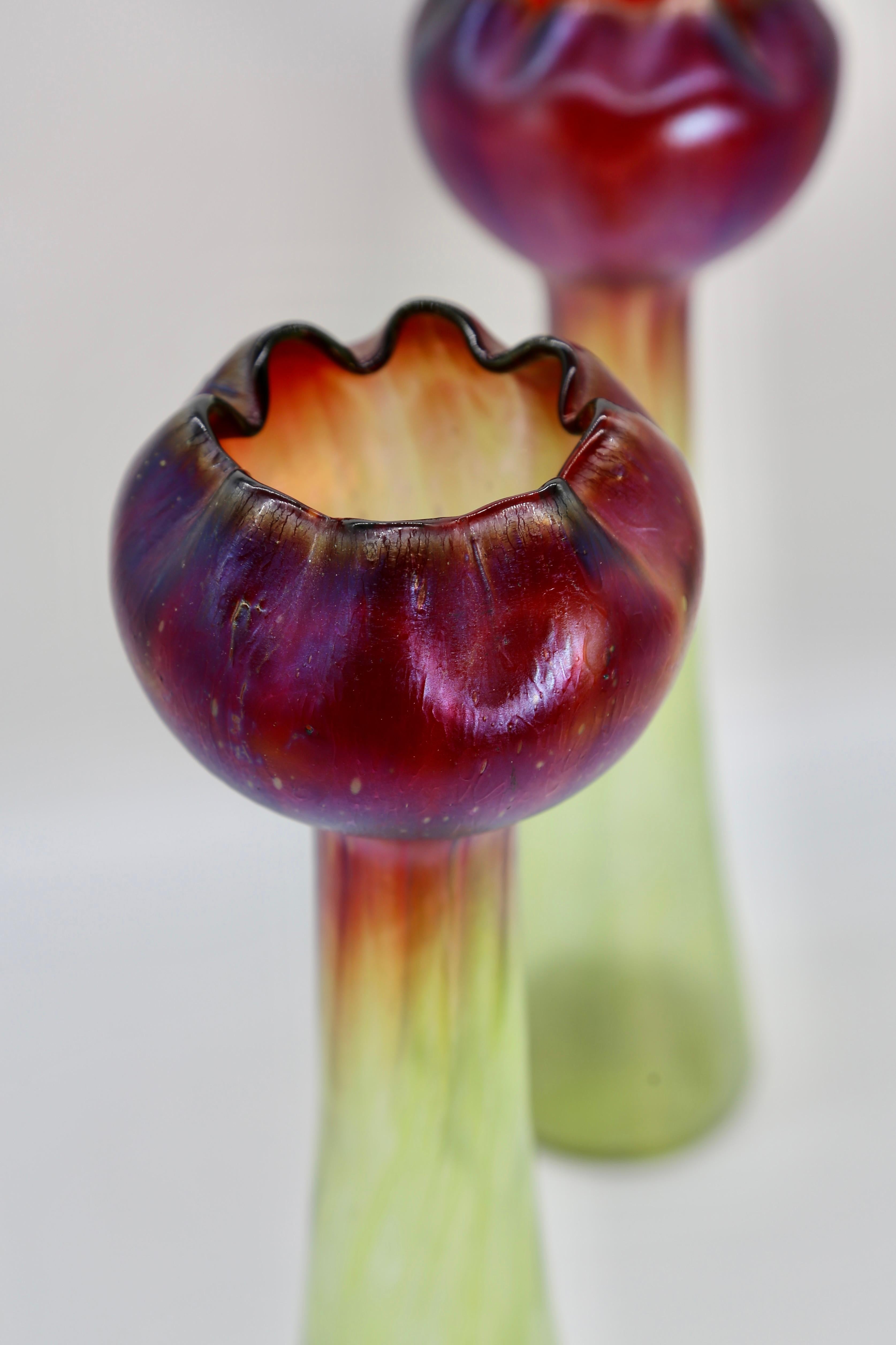 Rare paire de vases Loetz en verre de Bohême, avec un gracieux motif de tulipe, fabriqués par Johann Loetz Witwe dans les années 1880. Le vert et le rouge riche avec des reflets irisés argentés et bleus mettent en valeur ces beaux exemples gracieux