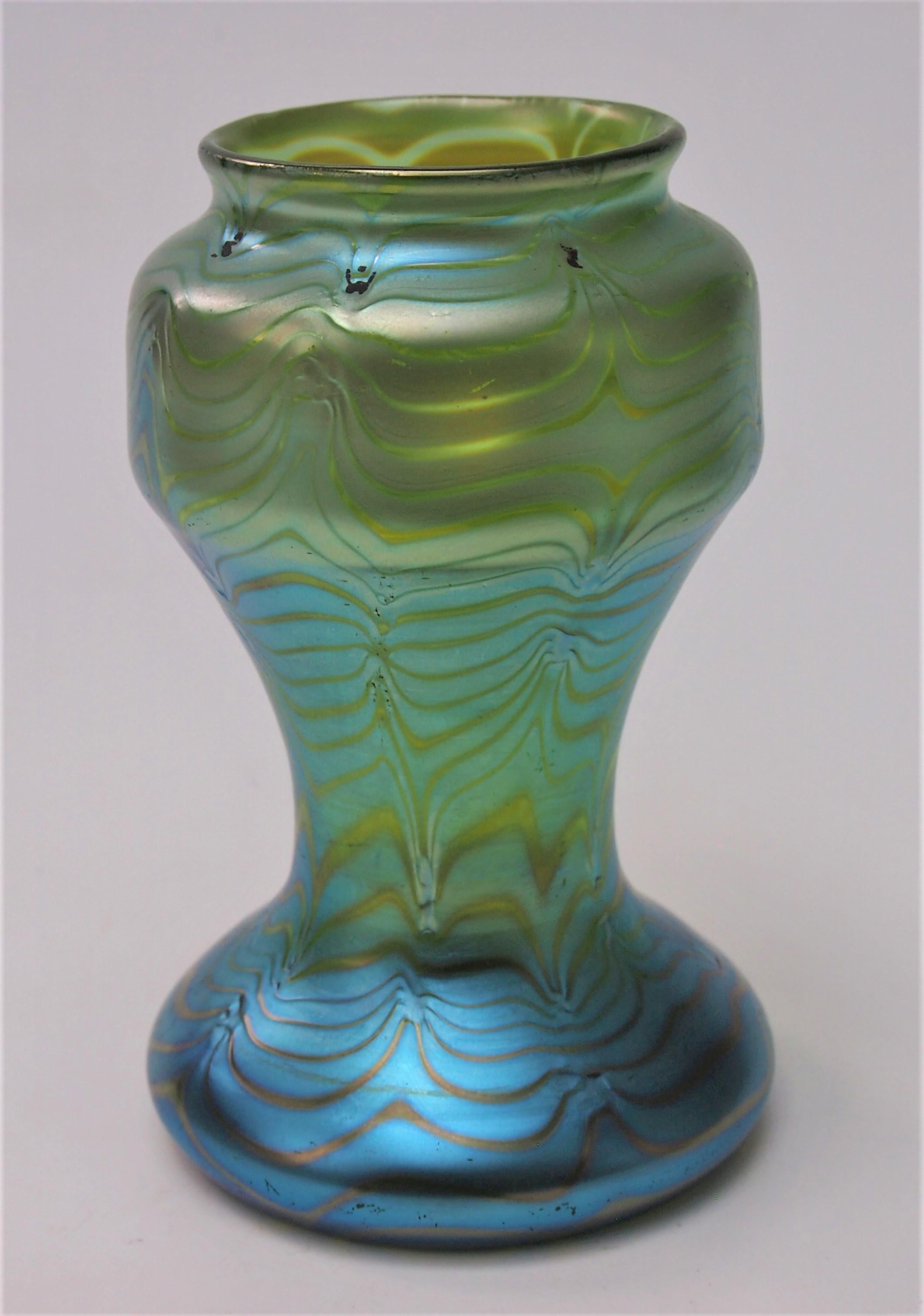 Fabuleux exemple de vase Loetz Phaenomen crete (base verte) ref 85/3780 fabriqué vers 1902. Le vase vert est recouvert d'un plumage bleu argenté, qui a été travaillé à la main pour donner un aspect ondulé. Notez que les marques d'usinage laissent de
