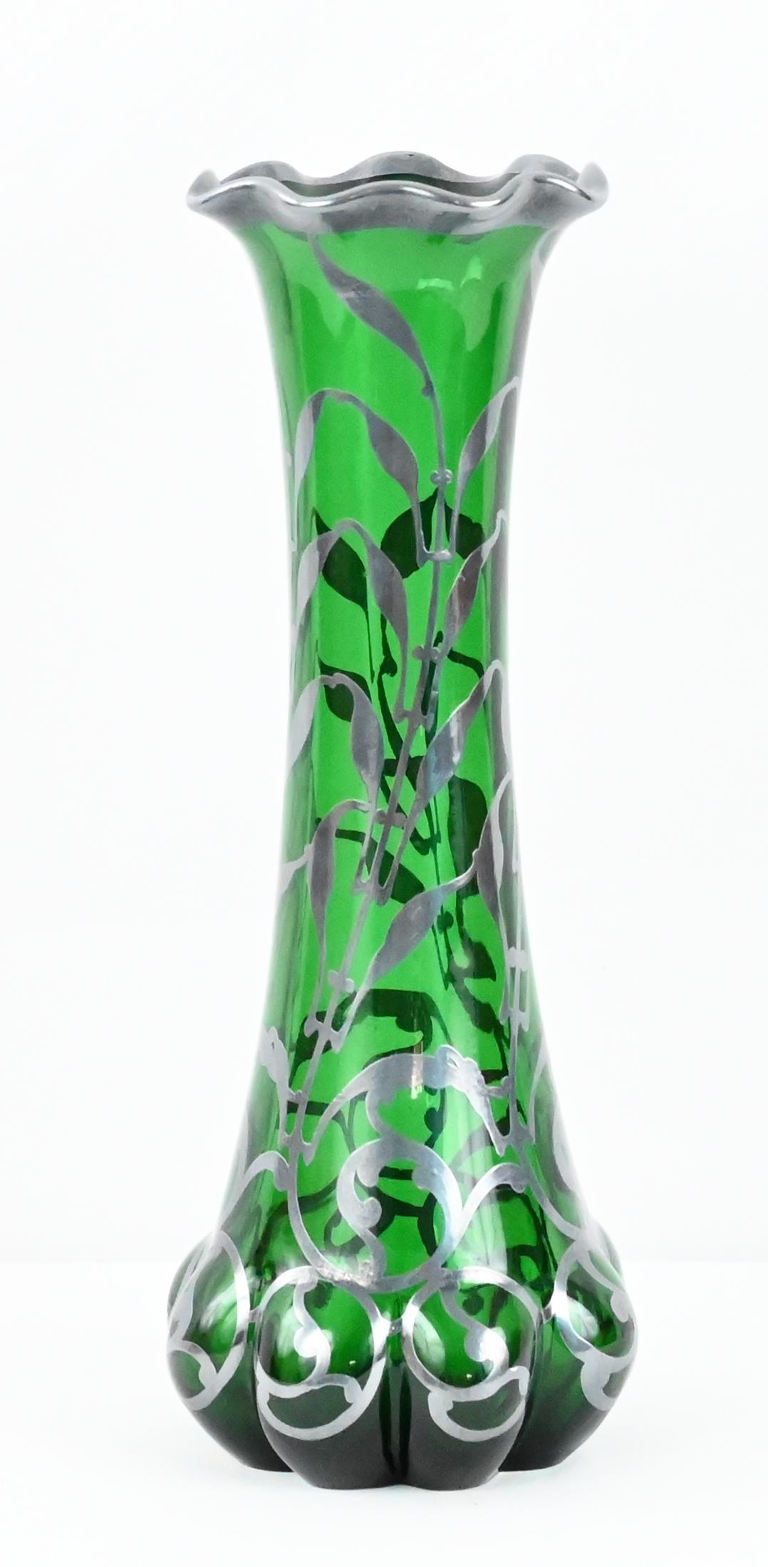 A fine quality Art Nouveau style art glass vase, by Loetz the historic glass maker from the municipality of Austria featuring Alvin Sterling Silver overlay. Overlay in form of open and horizontal patterns with stylized leaves and scrollwork.

A