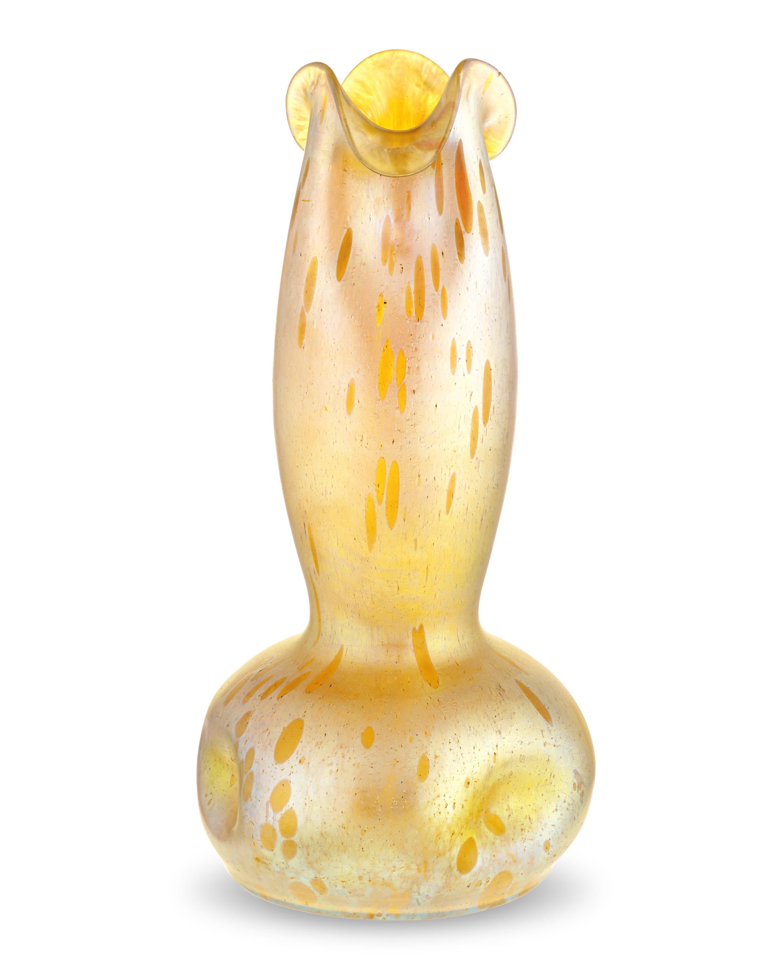 Forme circolari iridescenti in varie tonalità di giallo e oro adornano questo bellissimo vaso della rinomata ditta di vetri artistici boemi del XIX secolo Loetz Glass. Realizzato con un design a tromba e con la lucentezza tipica di Loetz, questo