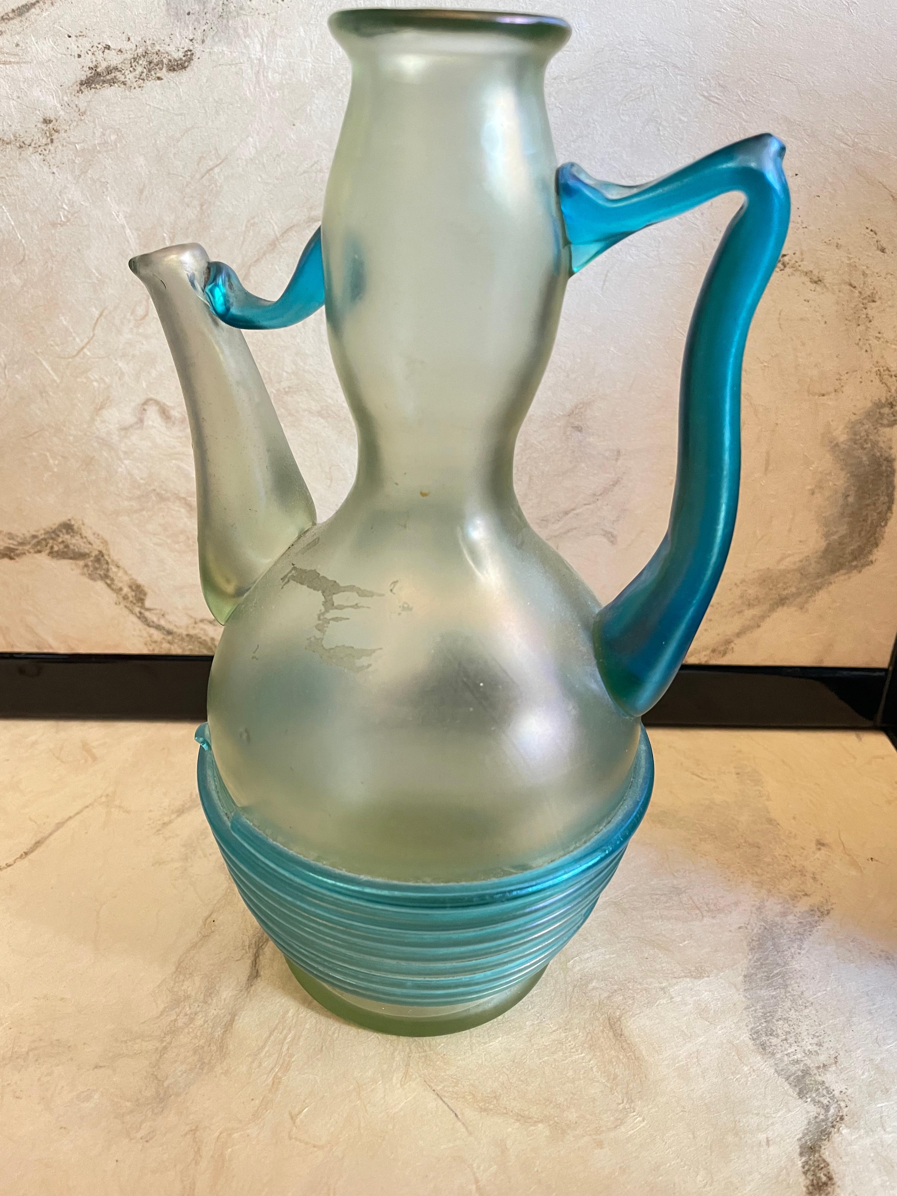 Loetz Orpheus c.1904 PN 1027. Olympia ground with regularly wound light blue threads and/or light blue nippled prunts.

This, likely Apéritif server, was made for Loetz's representative in Paris, Boudon & Klahr. This piece was originally designed