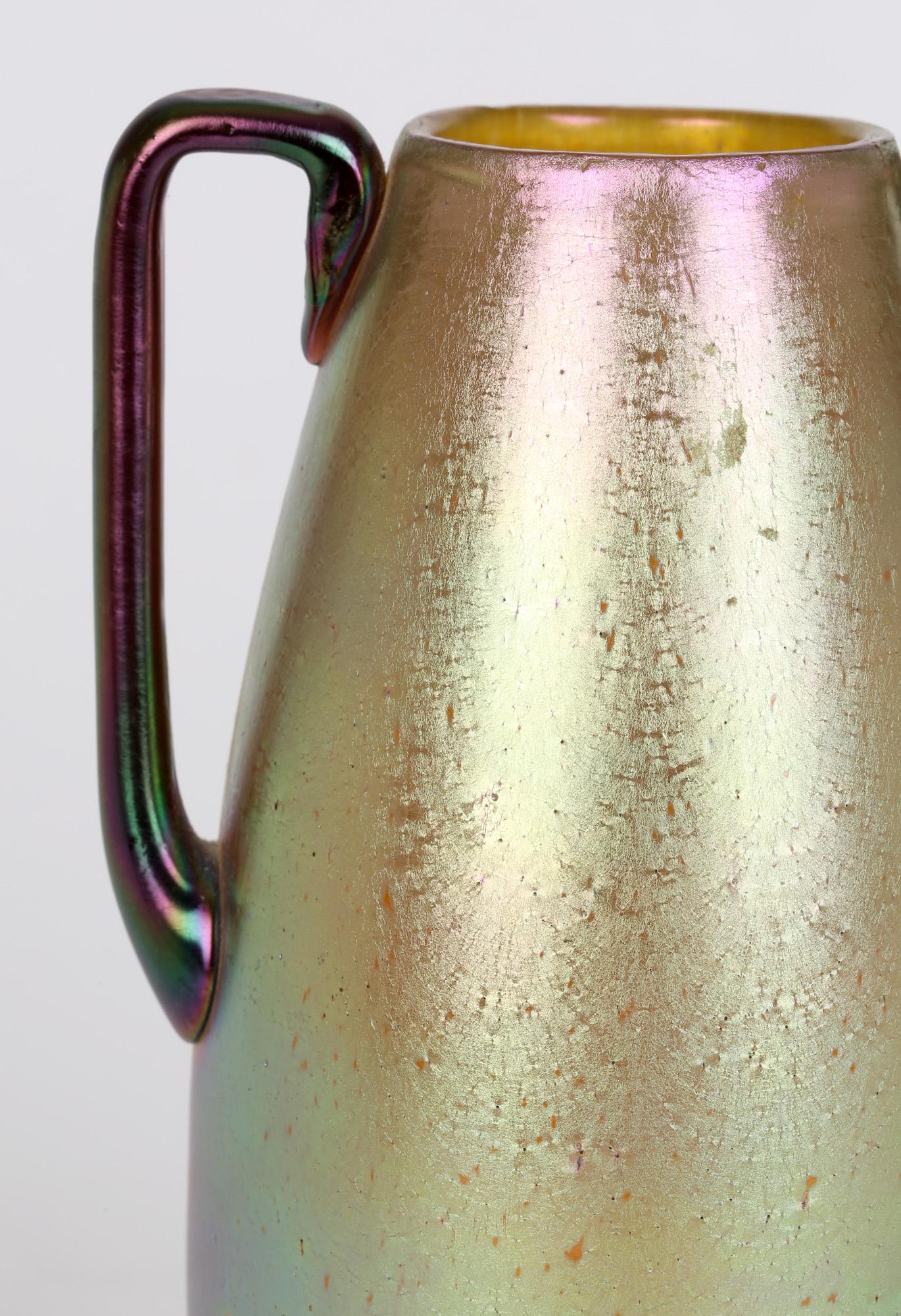 Elegante vaso in vetro cangiante di Boemia Silberiris Candia con manici marroni di Johann Loetz Witwe, risalente al 1900 circa. Il vaso dalla forma semplice, rif. PN 85/5151 del catalogo Loetz, presenta una meravigliosa iridescenza dorata dai