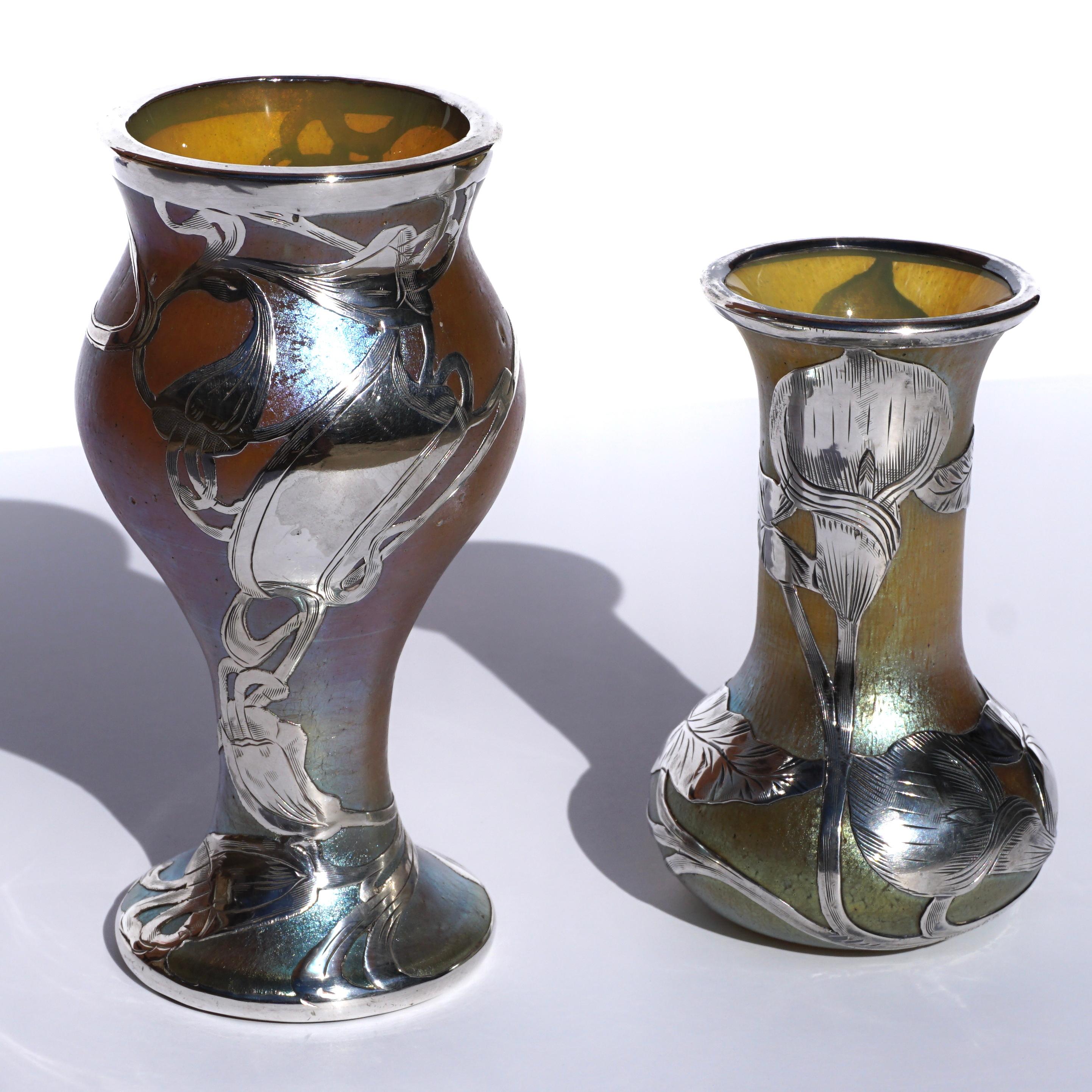 Loetz Art Nouveau circa 1900 art glass vases with floral and decorative scroll Silver Overlay. (Pair) 

Larger: Corset form in iridescent gold glass decorated with scrolling silver overlay and a blank cartouche.
Height: 5.25 X 2.75 Diameter