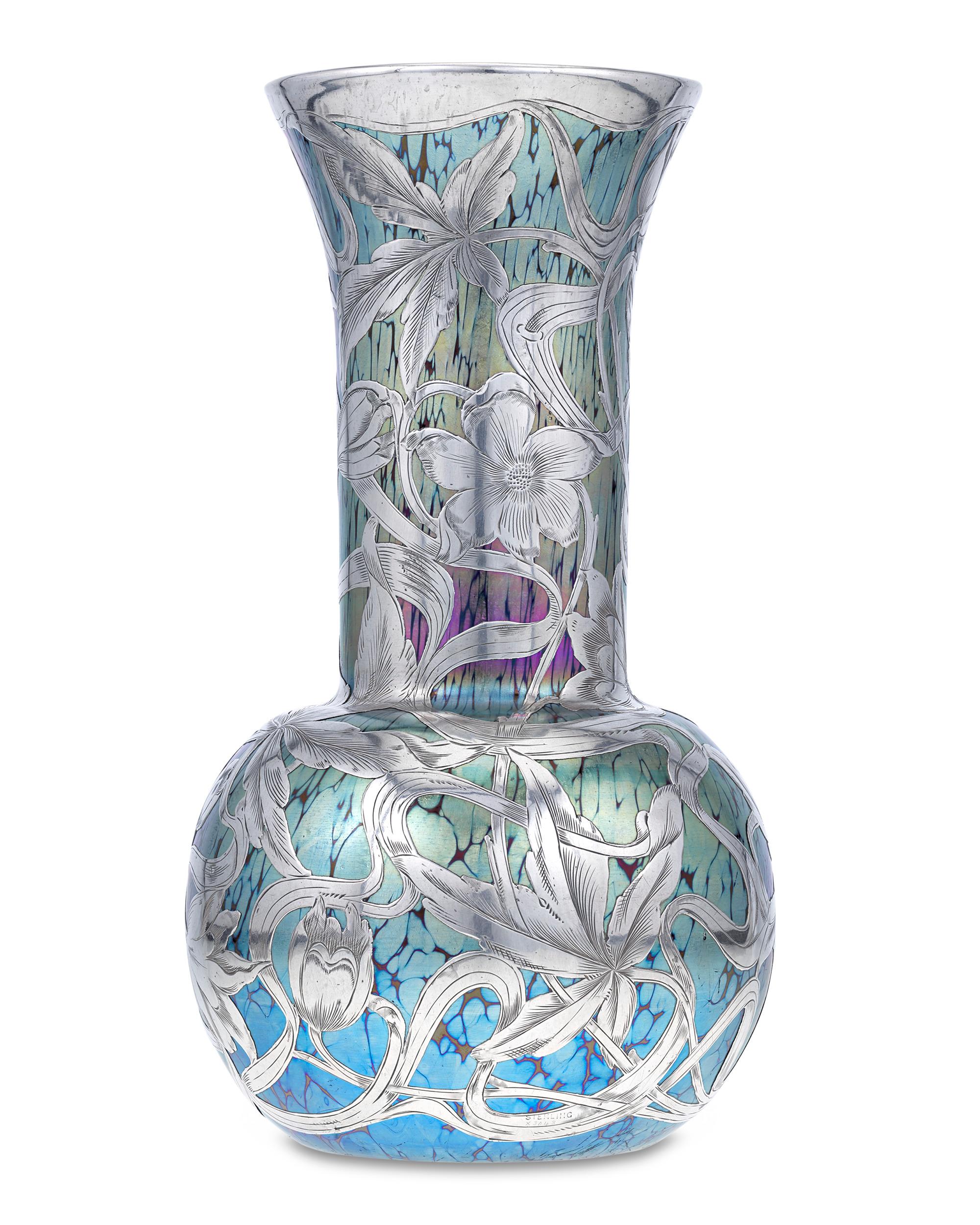 A paragon of Bohemian art glass artistry, this rare Loetz vase combines the beauty of the firm's jewel-toned glass with the brilliance of silver. The blue, green and purple glass features a stunning iridescent marble effect seen in Loetz's most