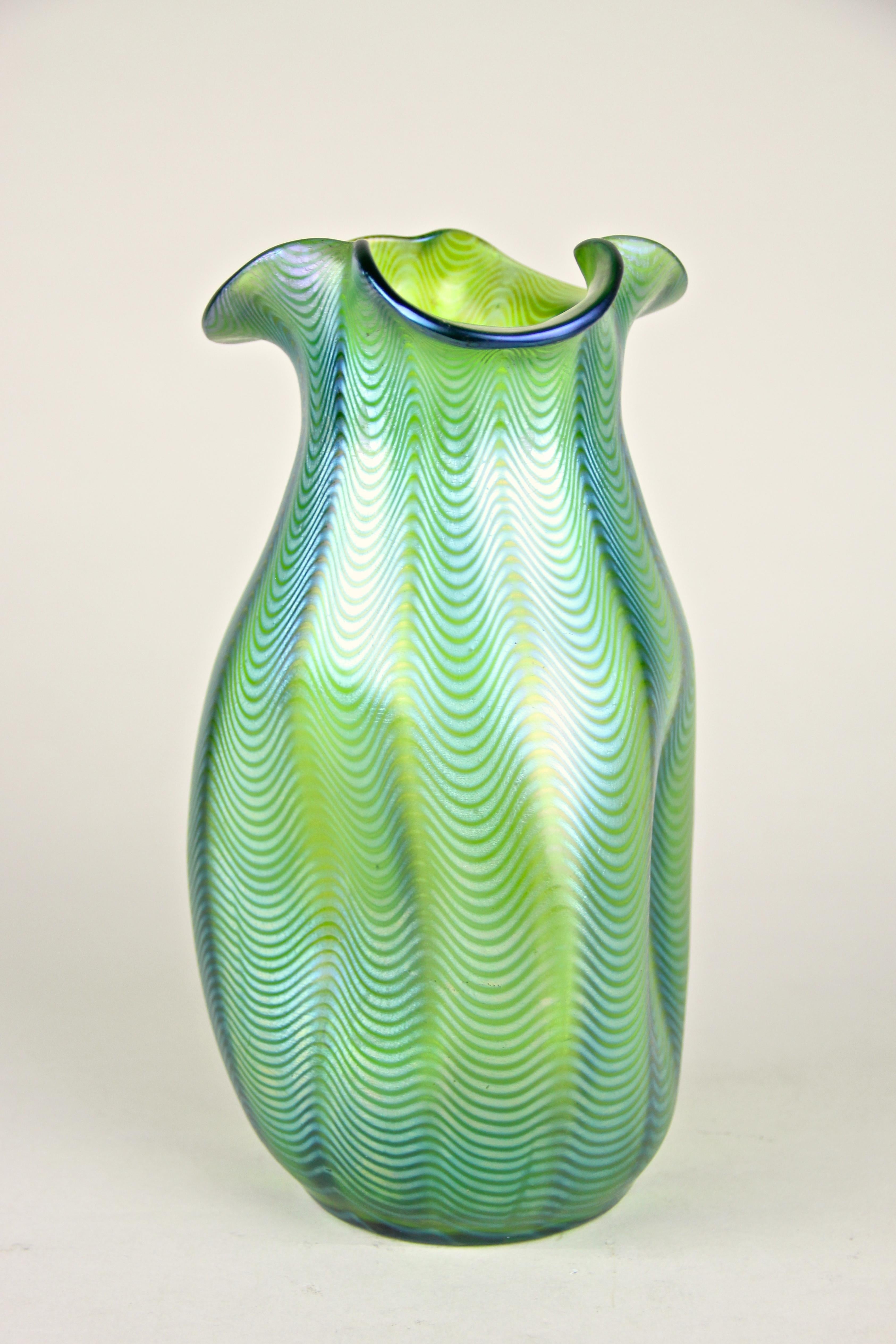Fantastic Loetz Witwe glass vase with the decoration Crete Phaenomen 6893 made in the famous workshops in Klostermuehle/ Bohemia, circa 1898. This rare execution PN I-7529 shows a lovely green glass base wound with silver yellow, warped into a wave