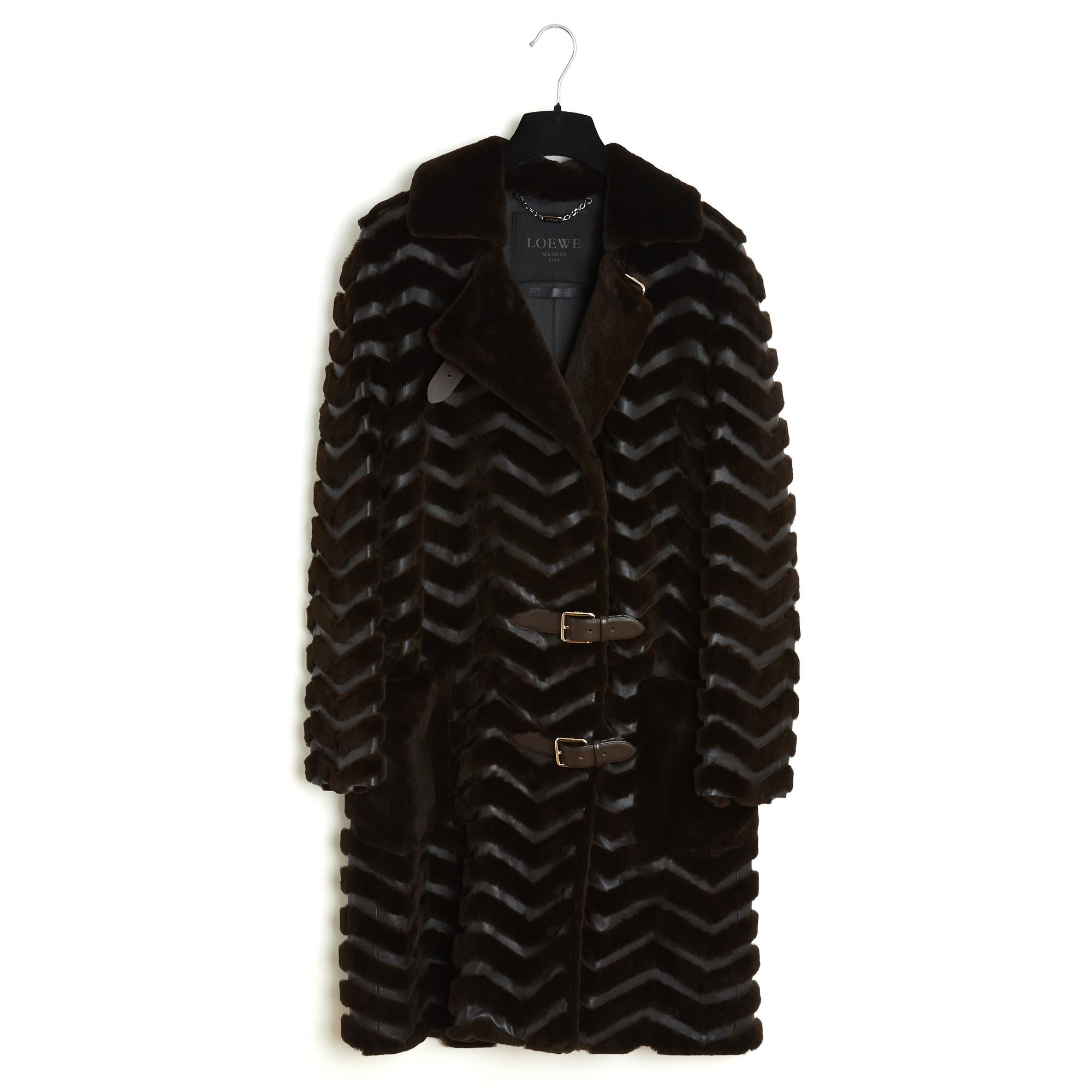 Loewe Mantel Herbst/Winter 2013, mittellang, gerader Schnitt, aus dunkelbraunem Leder und geschorenem Fuchspelz im Fischgrätenmuster, klassischer Kragen, der mit drei Lederriemen und (leicht) goldfarbenen Metallstiftschnallen geschlossen wird, zwei