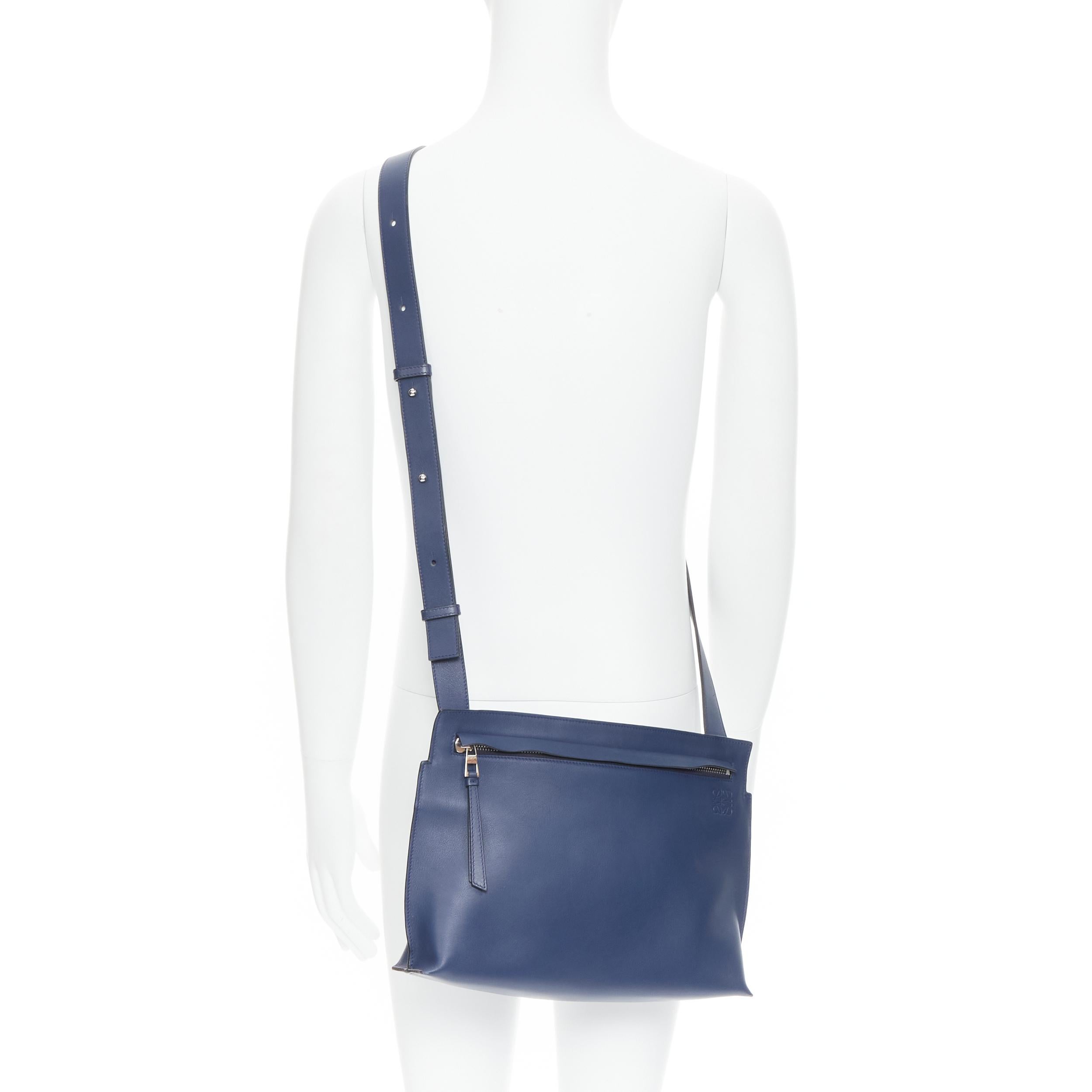 LOEWE 2017 T Messenger Messenger-Umhängetasche aus marineblauem Leder mit Reißverschluss und Logo 
Referenz: TGAS/B01370 
Marke: Loewe 
Designer: JW Anderson 
Modell: T Messenger Marine Blau 
MATERIAL: Leder 
Farbe: Marineblau 
Muster: Solide