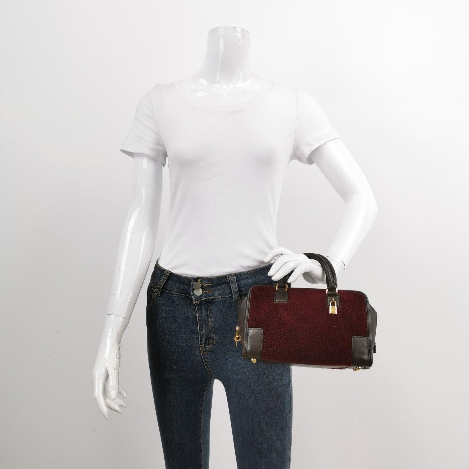 Loewe Amazona 23 in Burgundy Lambskin Leather and Shearling with Strap
These are professional photos of the actual bag.
  Top handle bag in boxy trunk style is back in fashion in 2024 thanks to shows by Prada and Miumiu. The Loewe Amazona bag is a