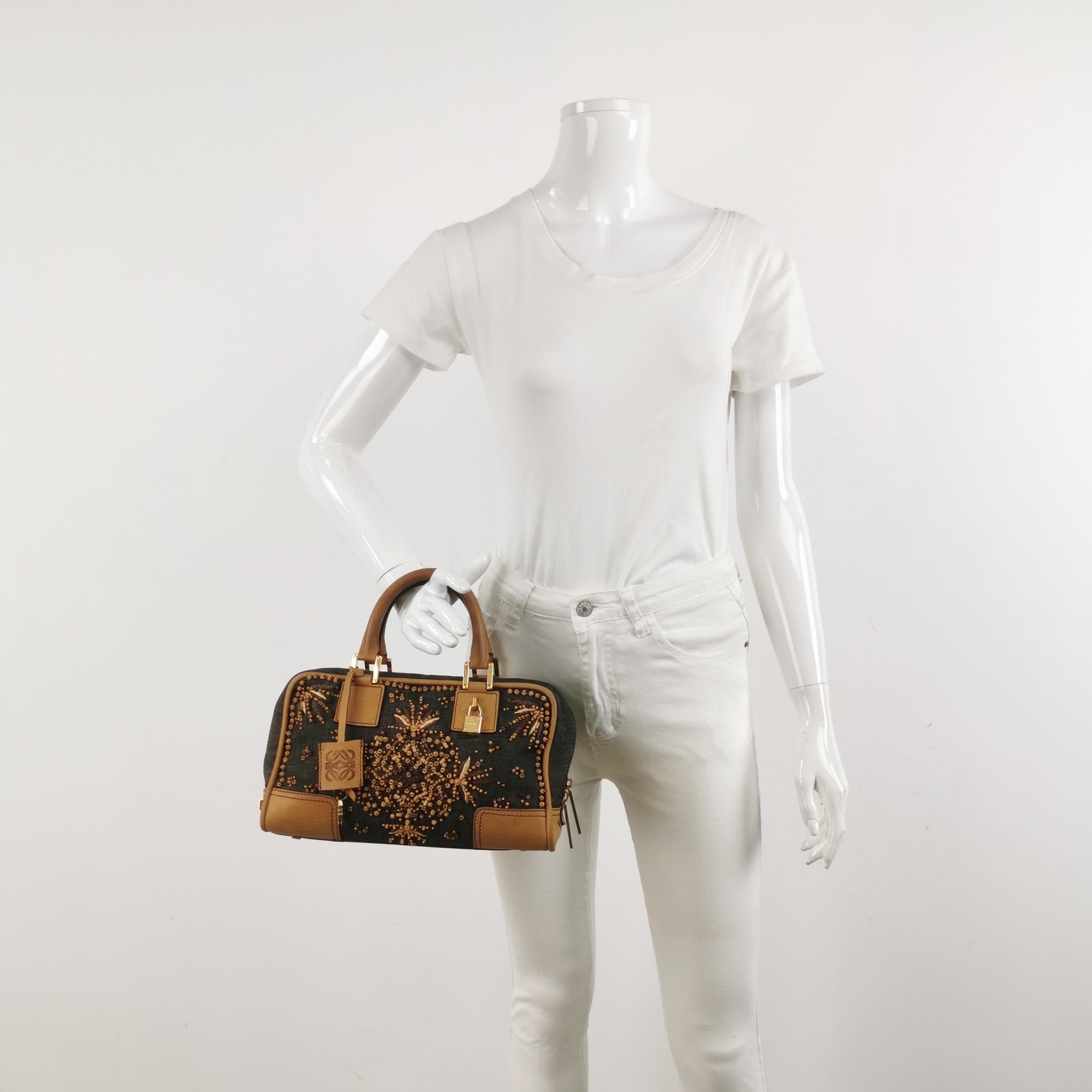 Top handle bag in boxy trunk style is back in fashion in 2024 thanks to shows by Prada and Miumiu. The Loewe Amazona bag is a stylish and functional option for everyday use, with a structured yet soft shape. Originally designer in 1975 and inspired