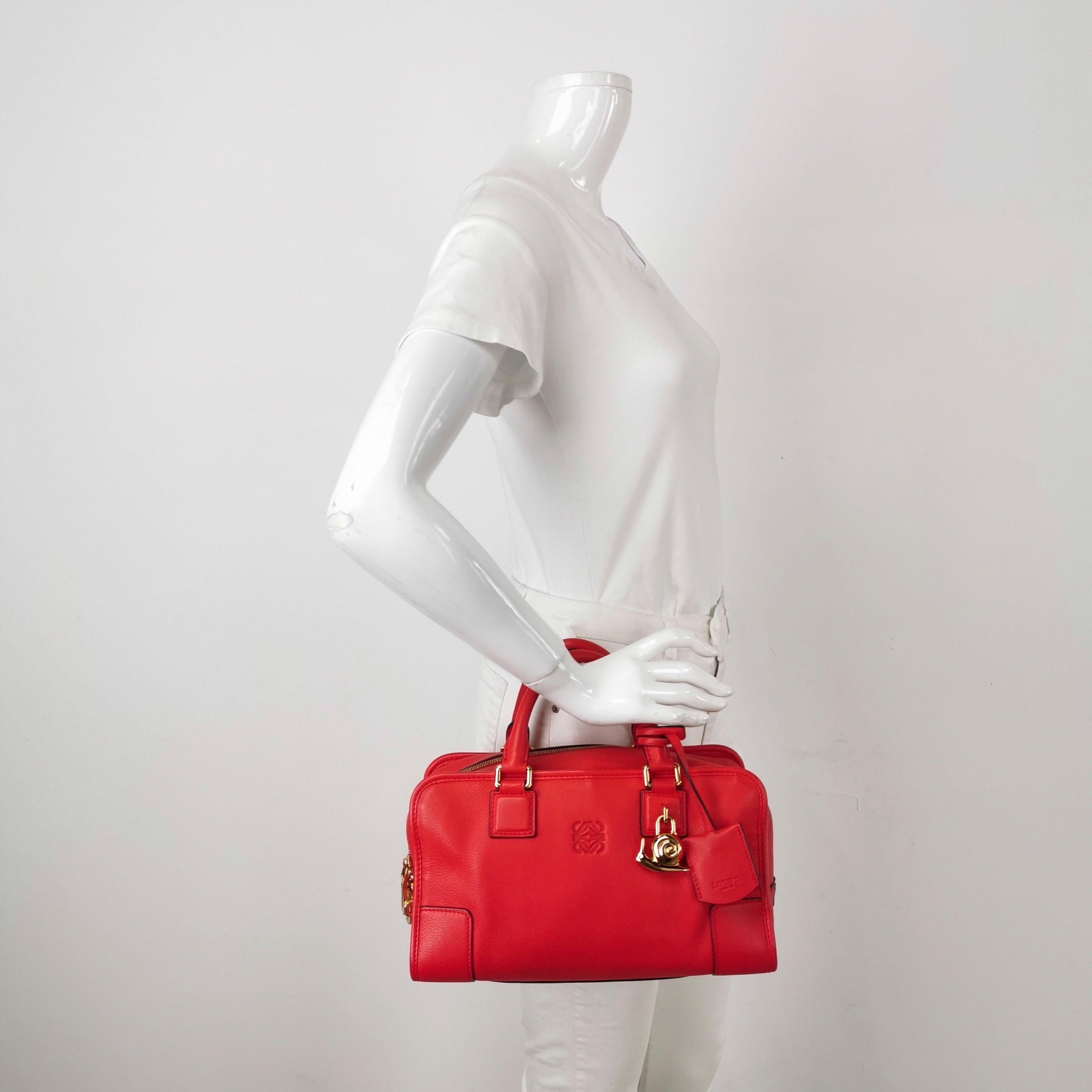Le sac à poignée supérieure dans le style tronc boxy revient à la mode en 2024 grâce aux défilés de Prada et de Miumiu. Le sac Loewe Amazona est une option élégante et fonctionnelle pour un usage quotidien, avec une forme structurée mais douce.