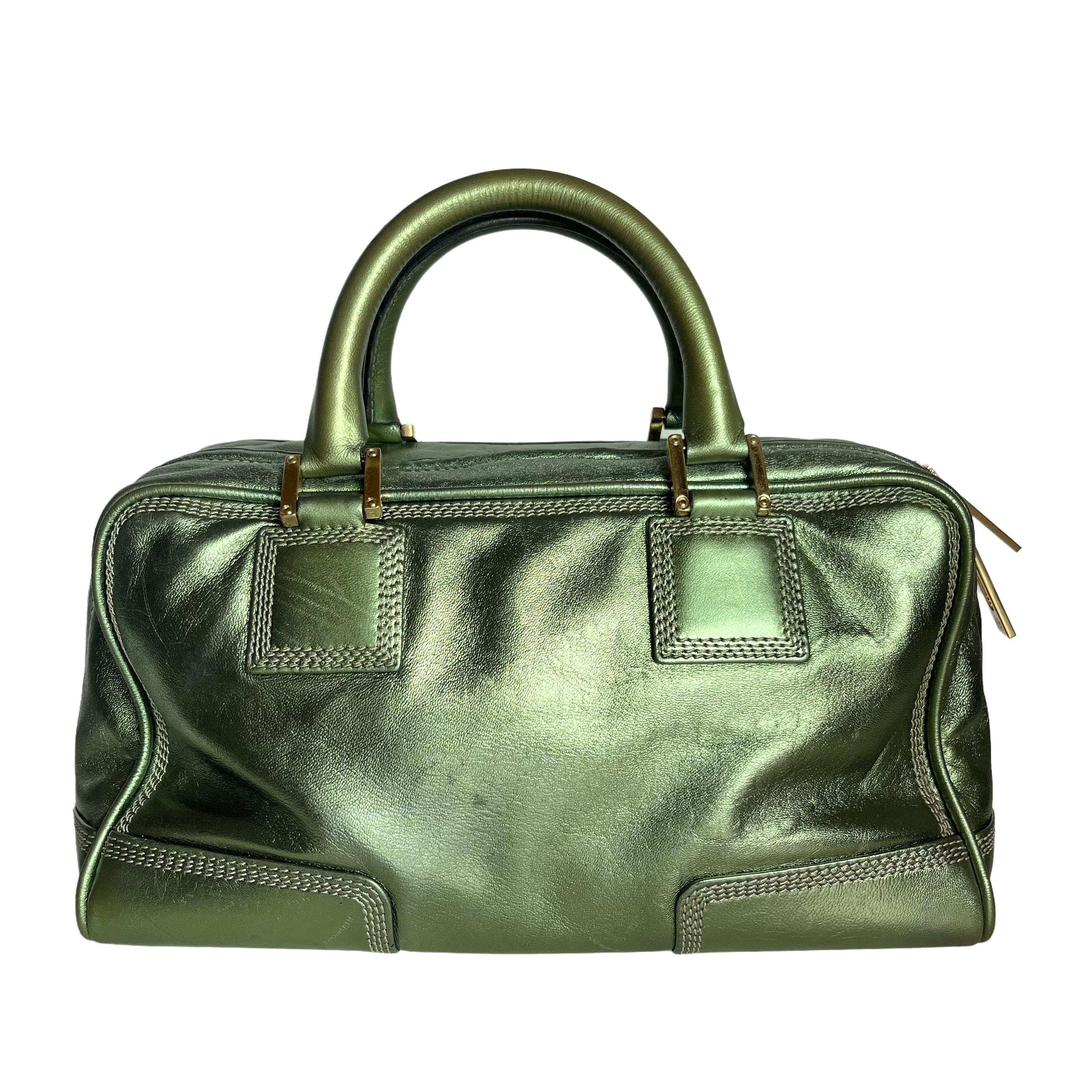 Top handle bag in boxy trunk style is back in fashion in 2024 thanks to shows by Prada and Miumiu. The Loewe Amazona bag is a stylish and functional option for everyday use, with a structured yet soft shape. Originally designer in 1975 and inspired