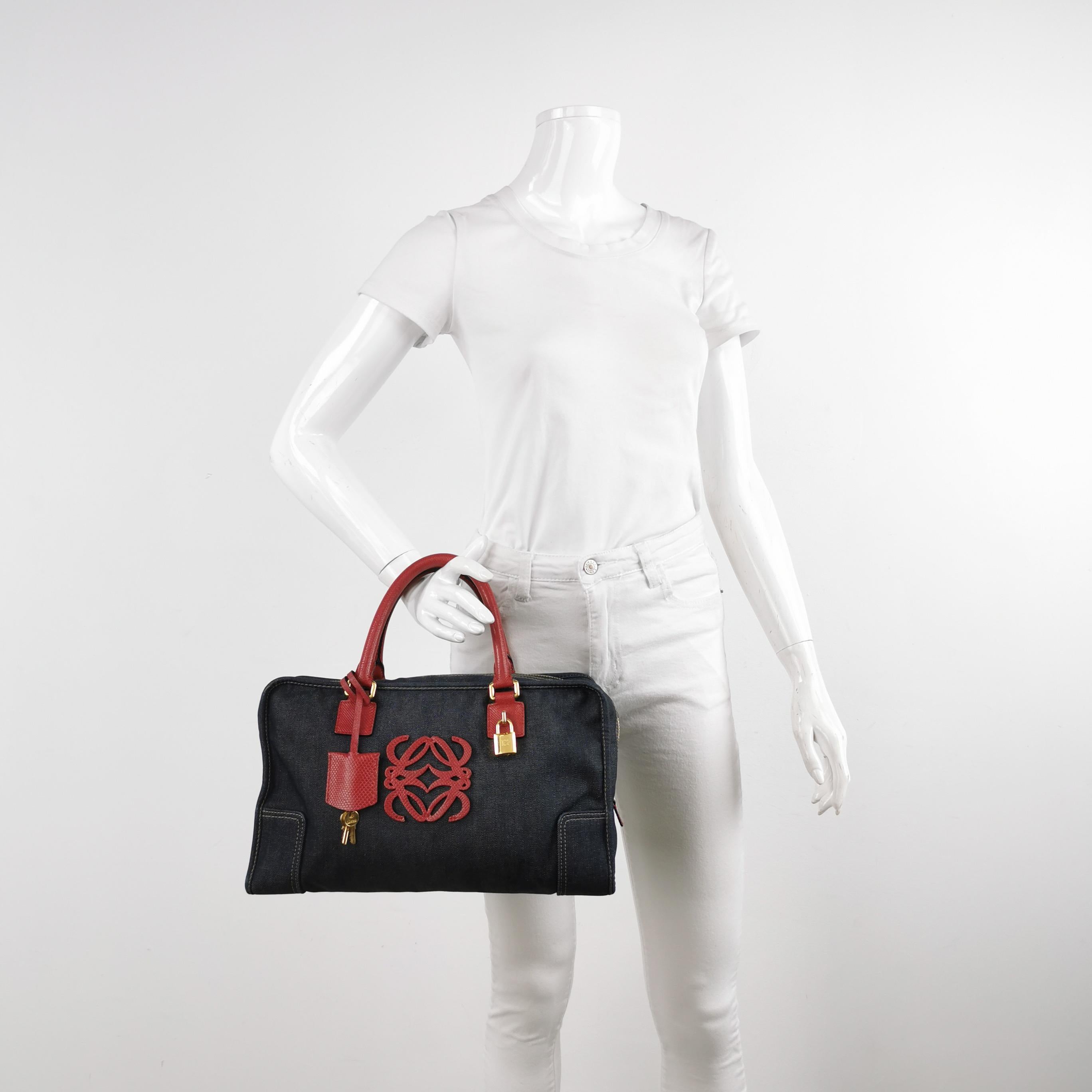 El bolso de asa superior estilo baúl vuelve a estar de moda en 2024 gracias a los desfiles de Prada y Miumiu. El bolso Loewe Amazona es una opción elegante y funcional para el día a día, con una forma estructurada pero suave. Diseñada originalmente