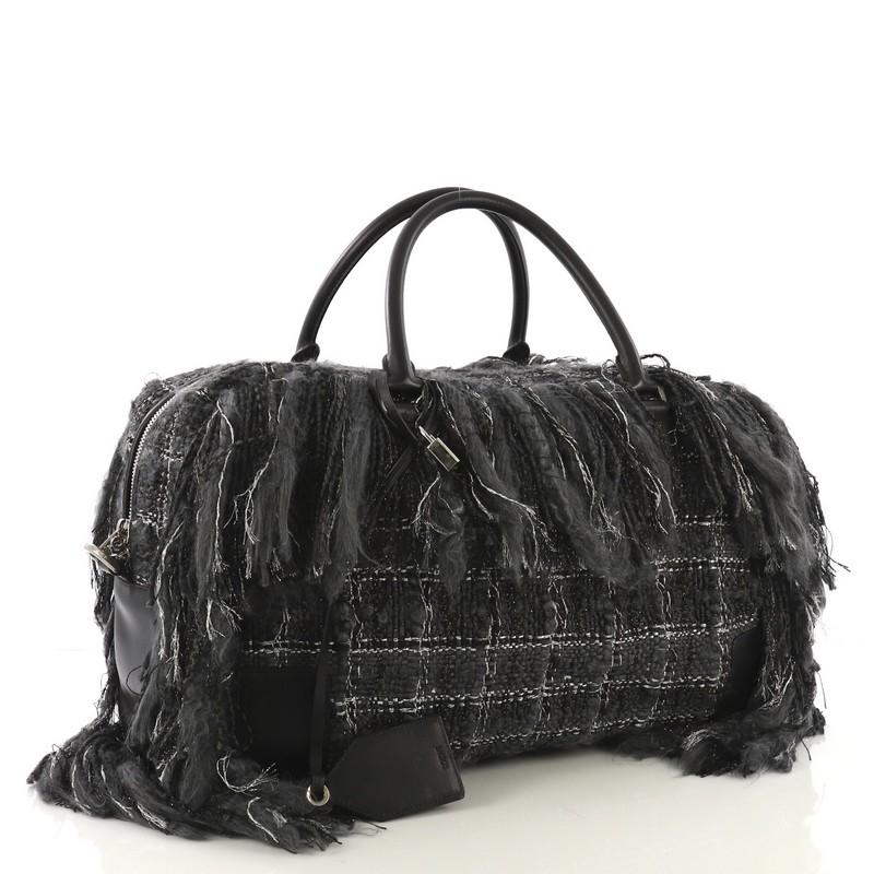 This Loewe Amazona Bag Fringe Tweed 45, crafted in black tweed, features dual rolled leather handles, fringe detailing and silver-tone hardware. Its zip closure opens to a brown suede interior with zip pocket. 

Estimated Retail Price: