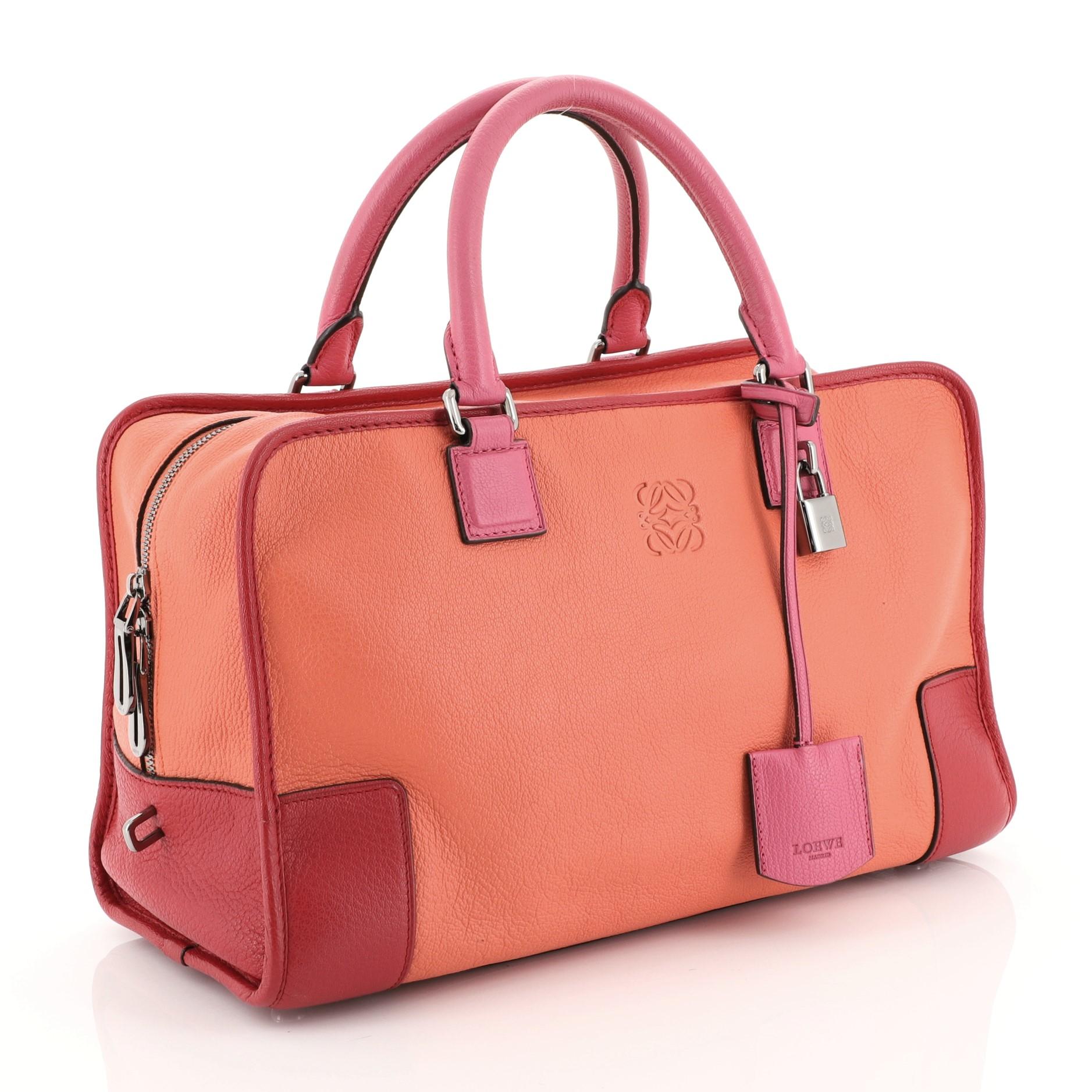 This Loewe Amazona Bag Leather 36, crafted in orange, red and pink leather, features dual rolled leather handles, embossed logo at front, and silver-tone hardware. Its zip closure opens to an orange leather interior with zip and slip pockets.