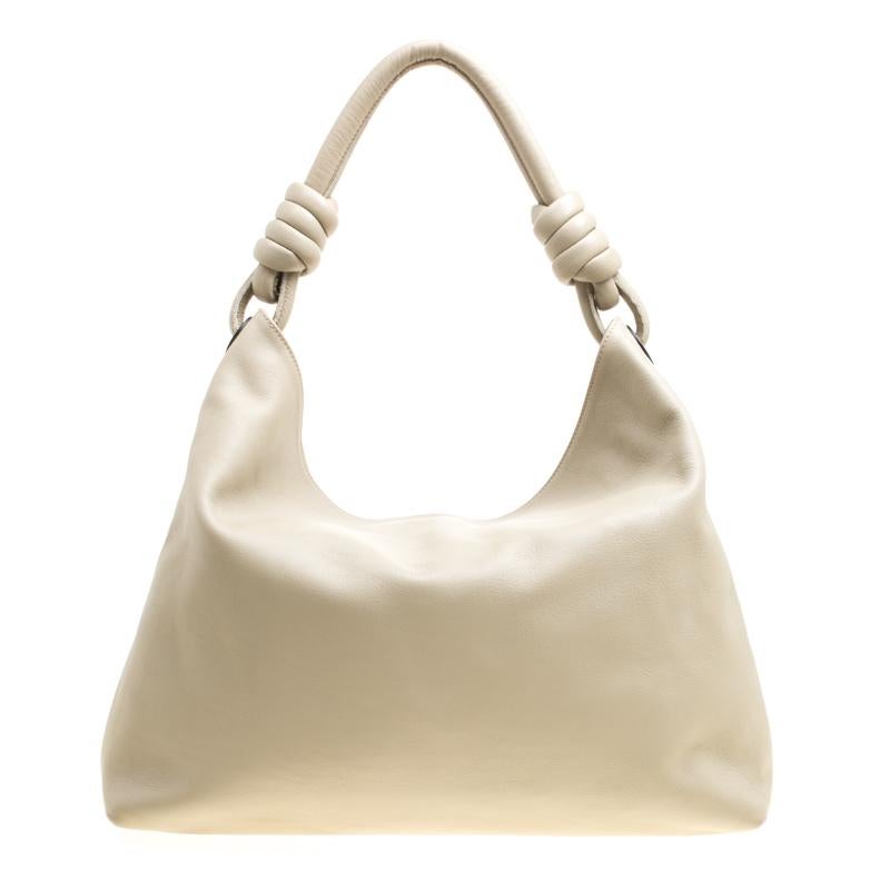 Quite stylish and easy to hold, this Flamenco hobo from Loewe is worth investing in. The beige hobo is crafted from leather and features a handle strap with a knot detailing on the sides. The top closure opens to a spacious canvas lined interior