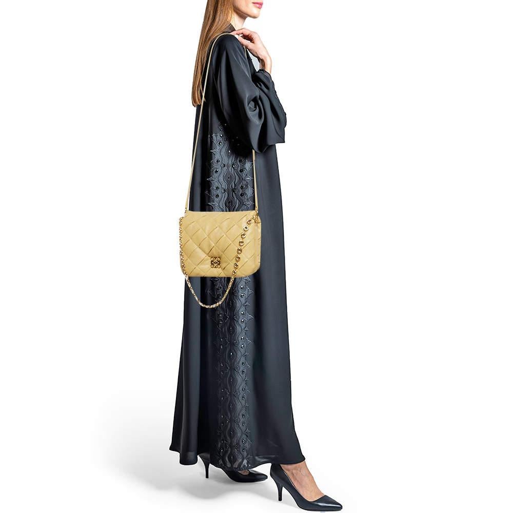 La bandolera Loewe Goya es un testimonio de artesanía refinada. Confeccionada en flexible piel beige, presenta un intrincado plisado que añade un toque de arte moderno. Su espacioso interior y su versátil correa para el hombro la convierten en la