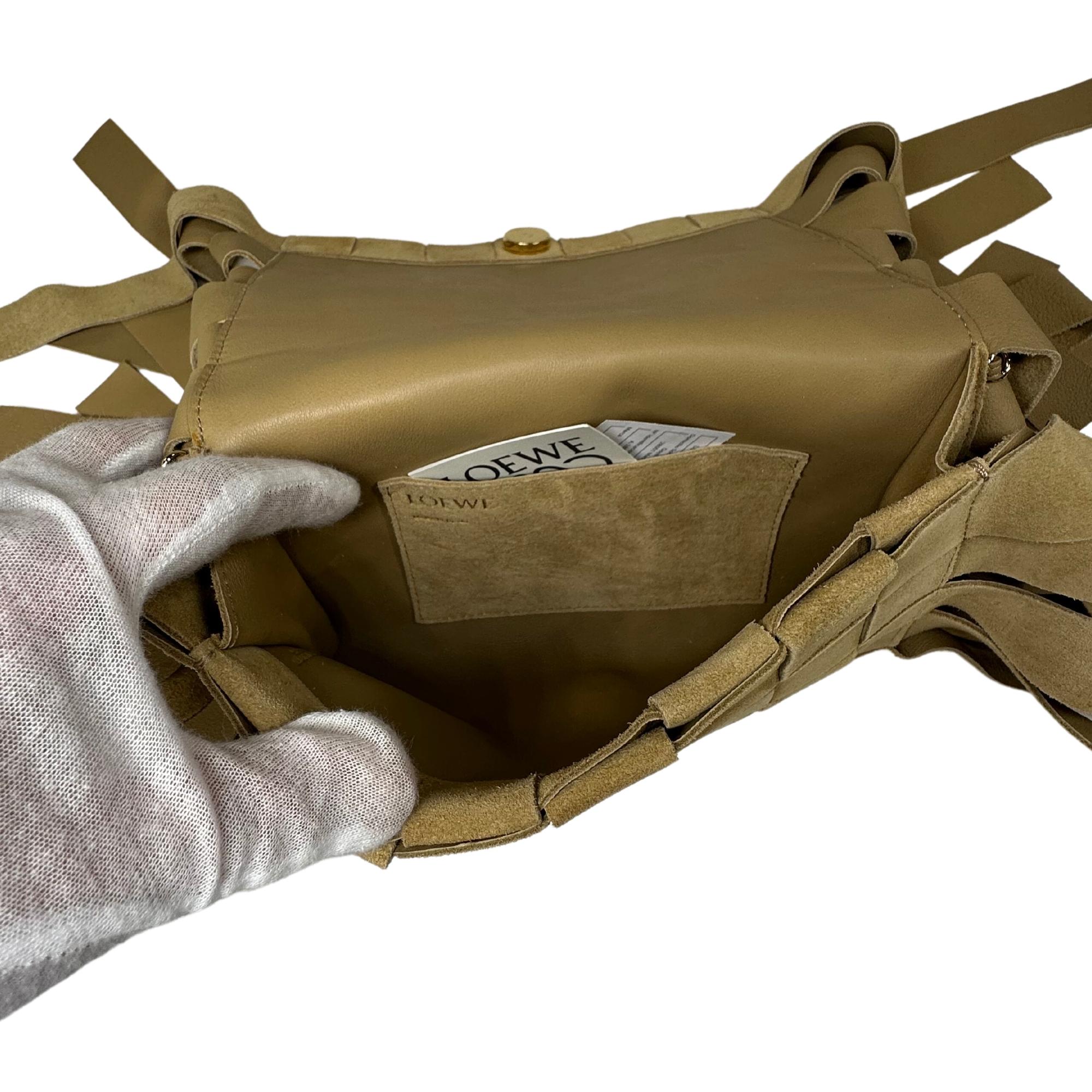 Loewe Crossbody Bag
Neutrals Suede
Gold-Tone Hardware
Single Adjustable Shoulder Strap
Fringe Trim Accent
Leather Lining & Single Interior Pocket
Snap Closure at Front
Includes Dust Bag

Shoulder Strap Drop Max: 21