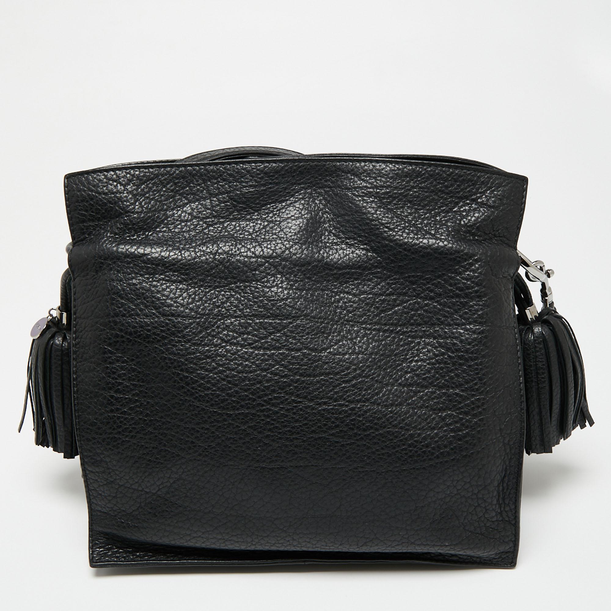 Understated and sophisticated, this Flamenco bag comes from the iconic house of Loewe. Crafted from quality leather, it comes in a classic shade of black. It is styled with lovely tassel detailing on the sides, a small embossed logo, a long shoulder