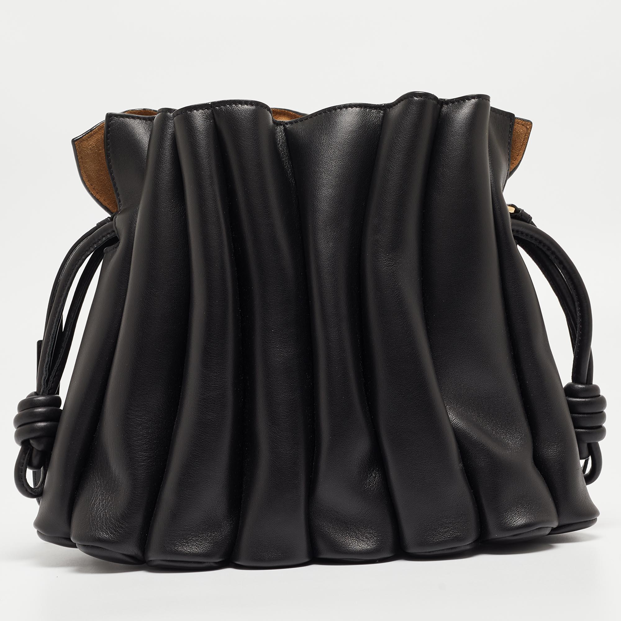Crafted from sumptuous black leather, the Loewe Flamenco bag exudes timeless chic. Its iconic knot detailing adds a touch of flair, while the adjustable shoulder strap ensures versatility. With its spacious interior and magnetic closure, it's both