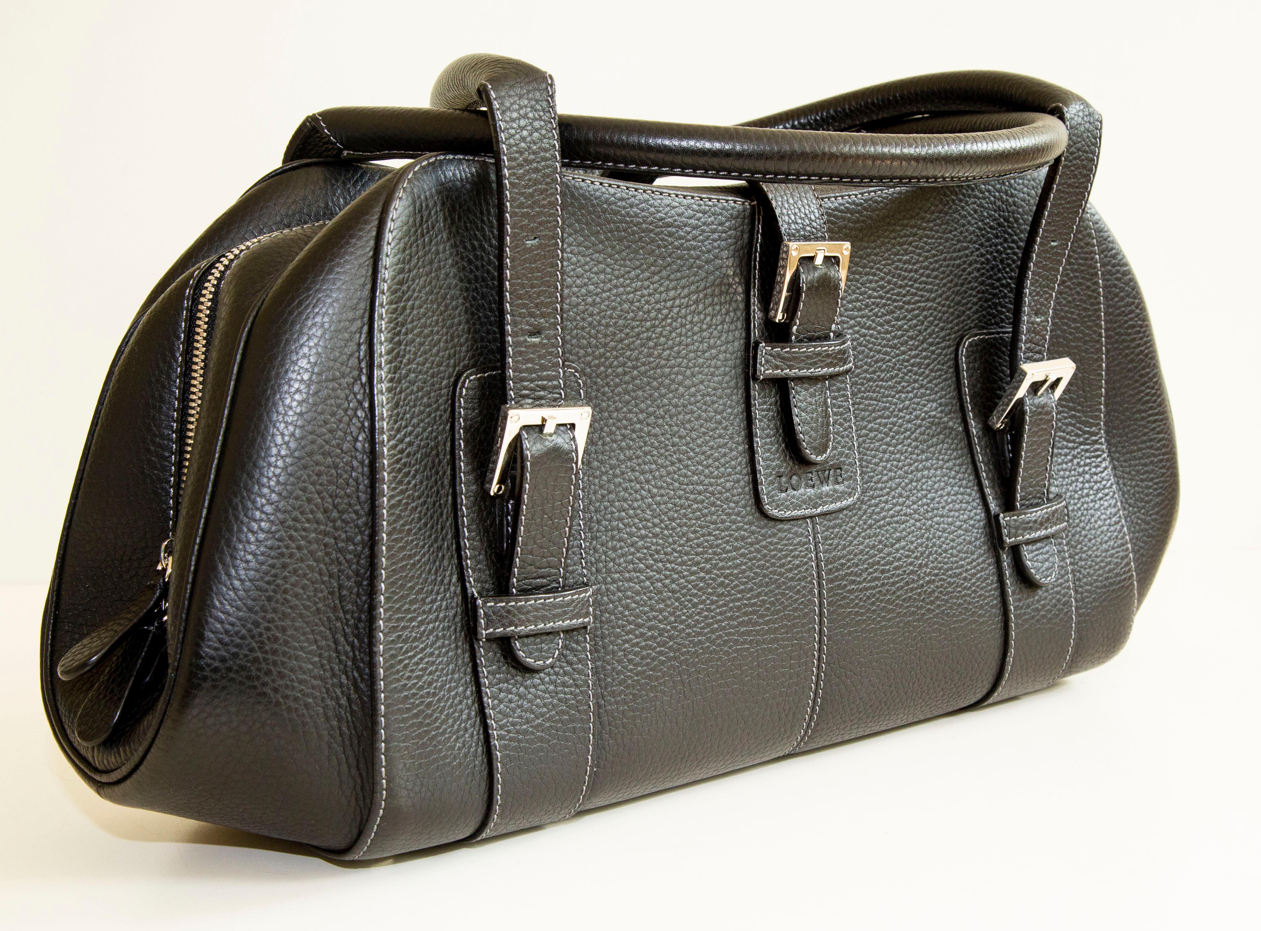 Un authentique sac à bandoulière Loewe. L'extérieur du sac est en cuir noir et le matériel est de couleur argentée. L'intérieur est doublé de tissu noir Loewe et comporte trois poches à glissière. L'intérieur est propre et soigné. L'extérieur et le