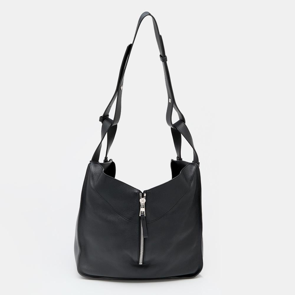 Loewe's high regard for unique designs and quality craftsmanship is exhibited in this Hammock shoulder bag. Crafted using black leather, the shoulder bag has a highlighting zip detail along the middle, dual short handles with an attached shoulder