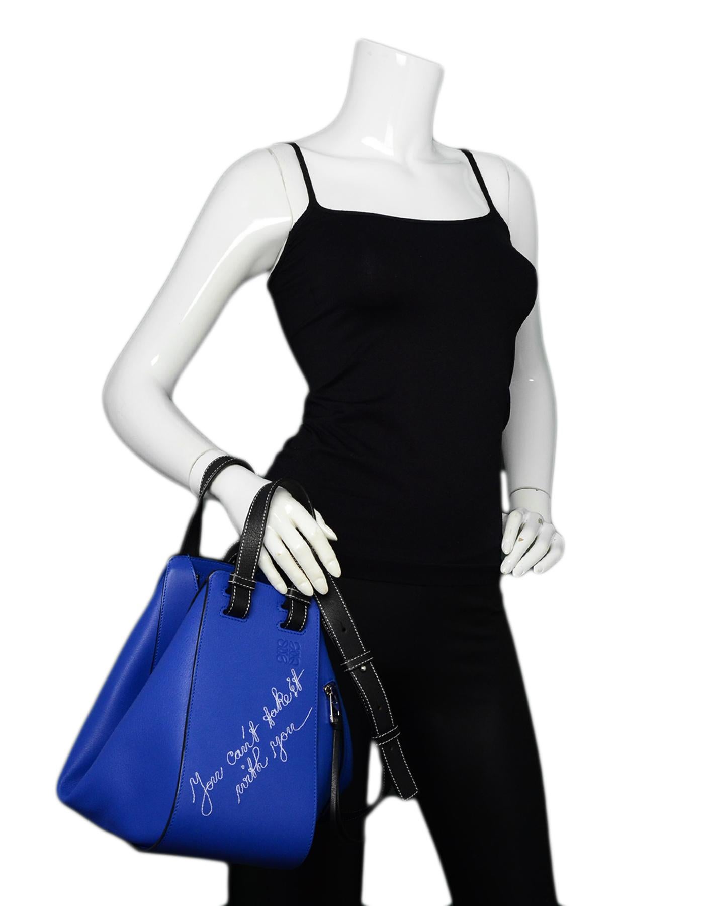 Loewe Blue Leather Can't Take It Small Hammock Bag. Features black handles and strap with contrast stitching and 'you can't take it with you' embroidered to front.

Made In: Spain
Color: Electric blue
Hardware: Silvertone hardware
Materials: Leather