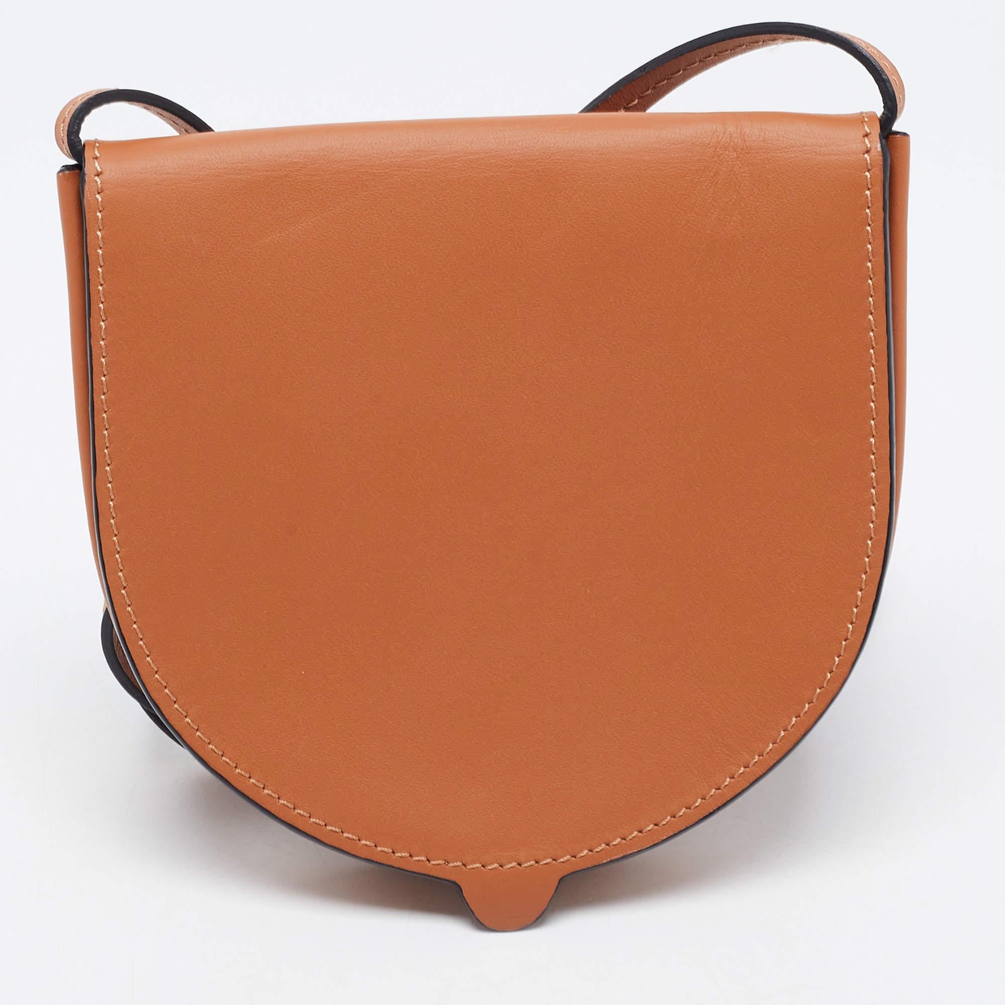 The Loewe bag is a stylish and compact accessory. Made from high-quality tan leather, it features a unique heel-shaped design. This mini bag is perfect for carrying small essentials and adds a touch of sophistication to any outfit with its sleek and