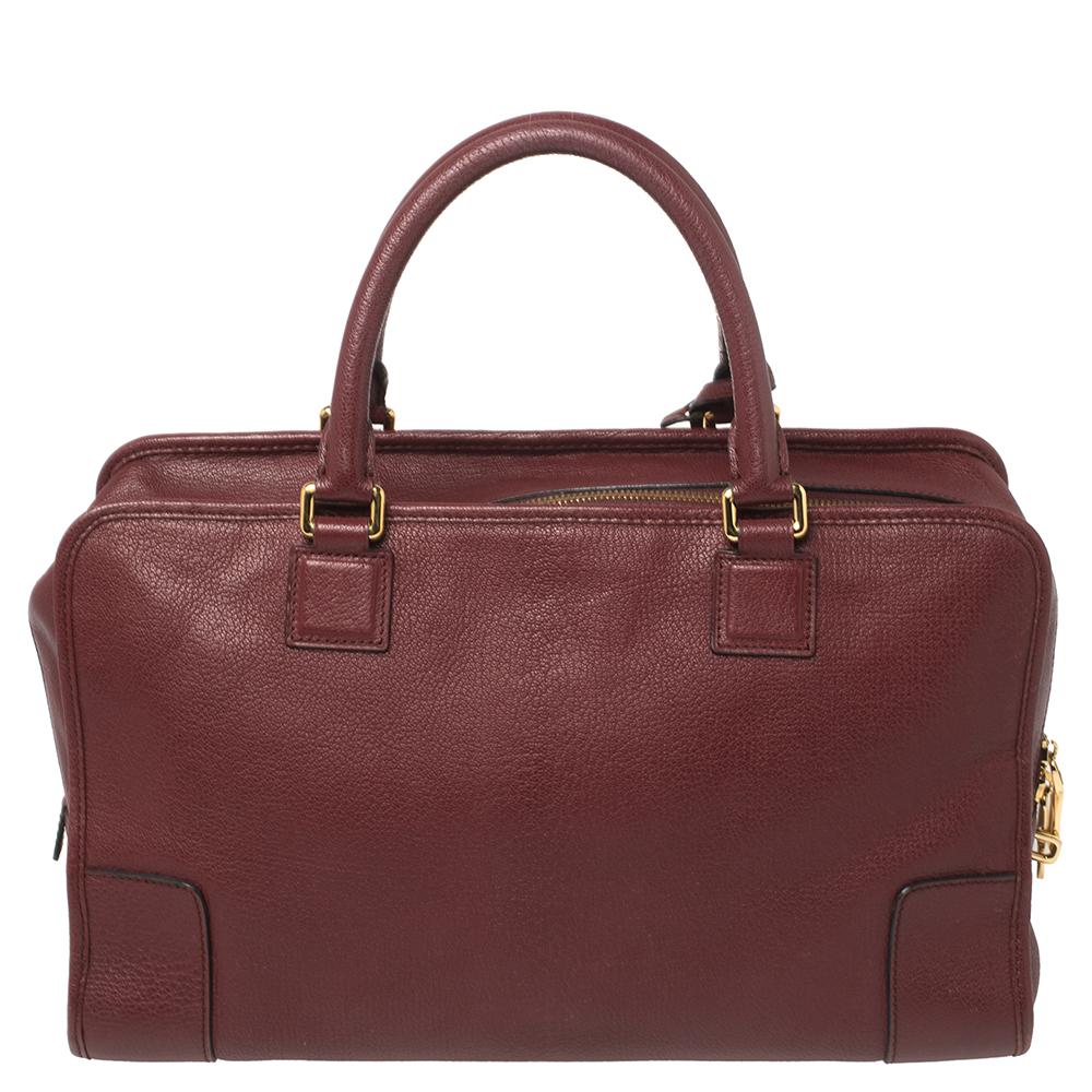 A spacious and stylish bag that can hold more than just your essentials with ease, the Amazona is one of the most popular bags from Loewe. A must-have for women on the go, it has a functional shape. Crafted in burgundy leather, this bag is accented