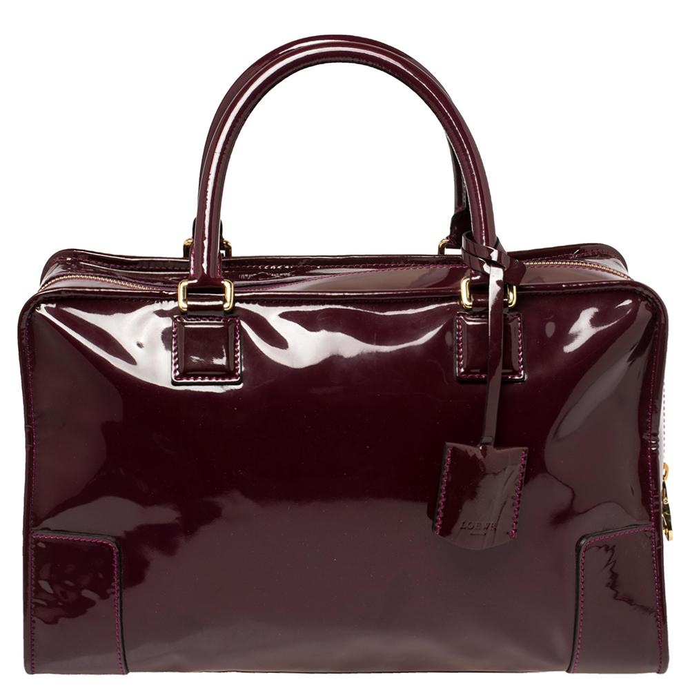 A spacious and stylish bag that can hold more than just your essentials with ease, the Amazona is one of the most popular bags from Loewe. A must-have for women on the go, it has a functional shape. Crafted in burgundy patent leather, this bag is