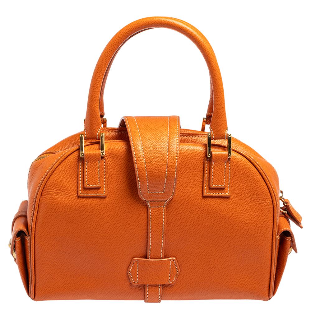 Spacious and captivating, this bowling bag is from Loewe. It has been crafted from leather and accented with gold-tone hardware. It is equipped with two leather handles and a well-sized fabric interior. Lastly, the bag is complete with protective