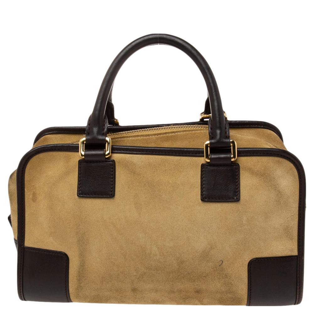 Update your designer collection by adding this Amazona 28 bag from the House of Loewe. It has been designed using cream, dark-brown suede and leather, with gold-tone hardware. It is held by dual handles and has a leather-lined interior. Carry your