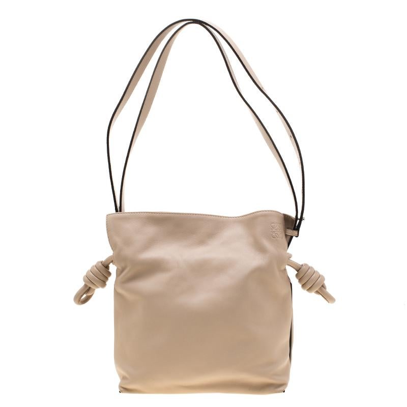 This Flamenco hobo comes with signature knot details on each side and looks subtle in its beige hue. The inside canvas is styled to exquisiteness to give flexibility in handling. This Loewe bag is the ideal adornment to go with your stylish clothing
