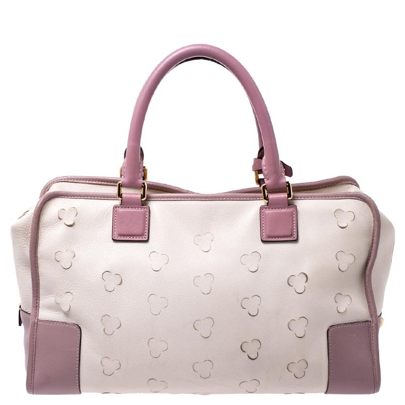 A spacious and stylish bag that can hold more than just your essentials with ease, this Loewe Amazona satchel is a must have for a woman on the go. Crafted in cream leather, this bag is accented with pink leather trims along with floral cutouts all