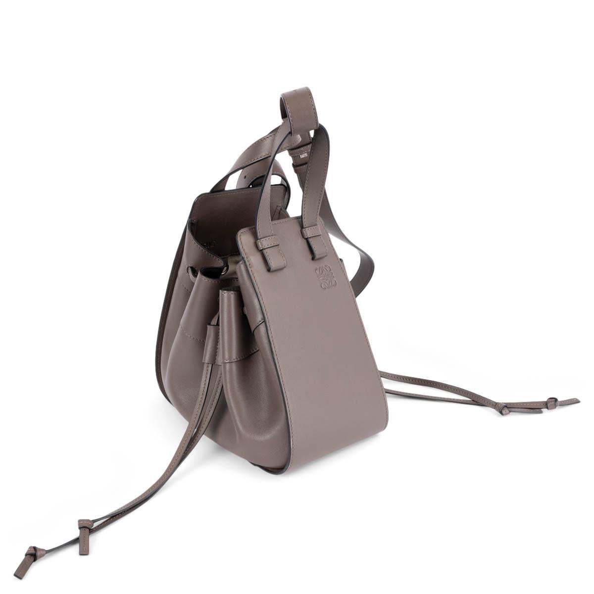 100% authentic Loewe Hammock Small shoulder in dark taupe calfskin. Features two half-round handles and is embellished with an embossed logo on the side. The design comes with a detachable and adjustable shoulder strap and drawstring closure on the