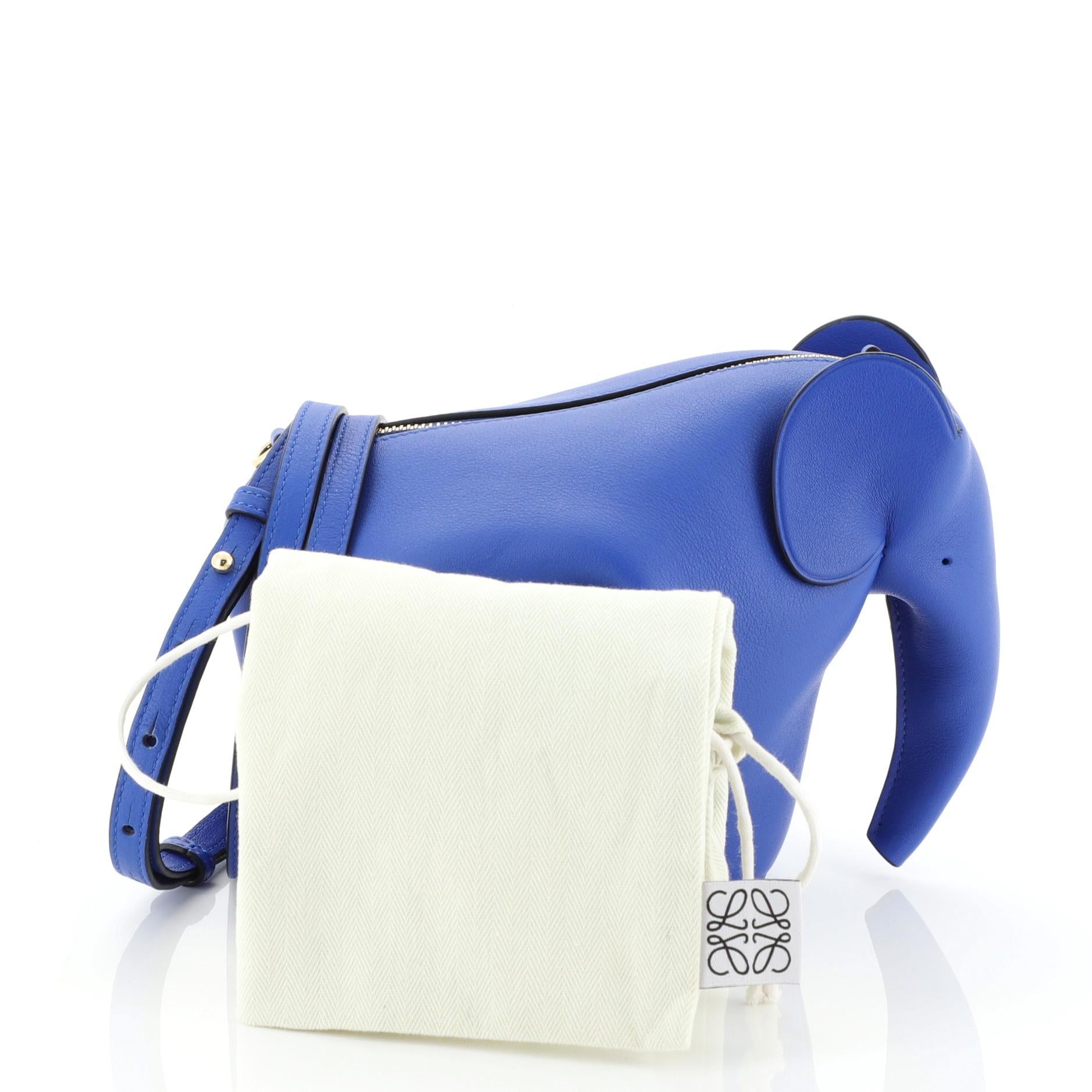 This Loewe Elephant Crossbody Bag Leather Mini, crafted in blue leather, features an adjustable crossbody strap, an elephant silhouette complete with a long trunk and dot-perforated 