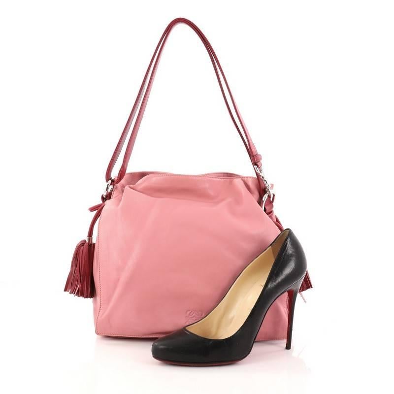 This authentic Loewe Flamenco Bag Leather is simply a must-have for your wardrobe. Crafted in pink leather, this classy stylish bag features leather shoulder strap, drawstring top with oversized tassels, and silver-tone hardware accents. Its