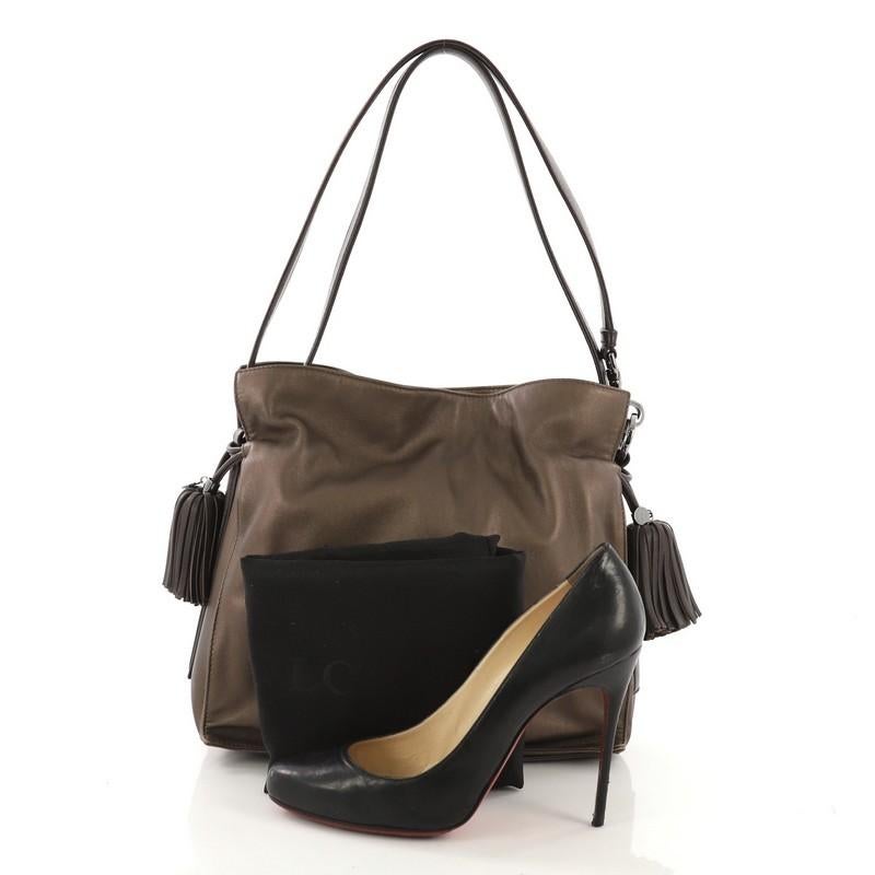 This Loewe Flamenco Bag Leather Medium, crafted in brown metallic leather, features leather shoulder straps, drawstring top with oversized tassels, and silver-tone hardware. Its drawstring closure opens to a beige fabric interior divided into three