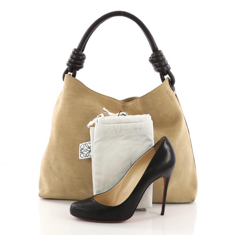 This Loewe Flamenco Knot Hobo Suede, crafted from beige suede, features a looping leather handle with knotted ends and gold-tone hardware. It opens to a beige fabric interior with zip and slip pockets. **Note: Shoe photographed is used as a sizing