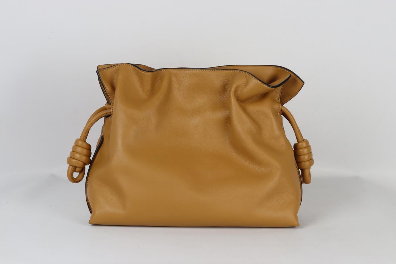 Loewe Flamenco leather clutch. Tan. Magnetic fastening at top. Comes with dustbag. Height: 8.5 in. Width: 11.6 in. Depth: 3.6 in. Min. Strap Drop: 19.5 in. Max Strap Drop: 21.6 in. Very good condition - Barely worn. Light mark to base; see pictures.
