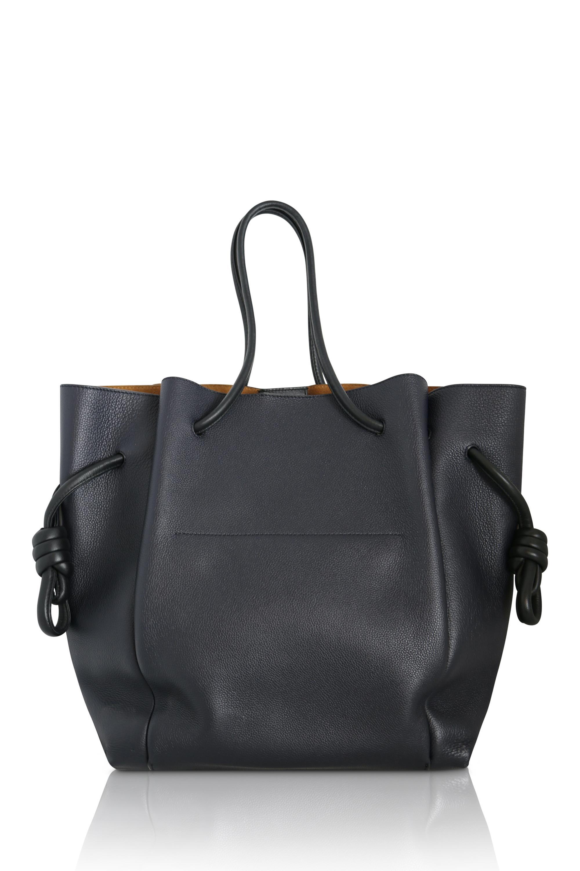 The Loewe Flamenco clutch bag is a timeless piece that combines modern style with a touch of vintage. Made with a leather exterior and knotted drawstring accents, this accessory is sure to make a statement that will never go out of fashion. An