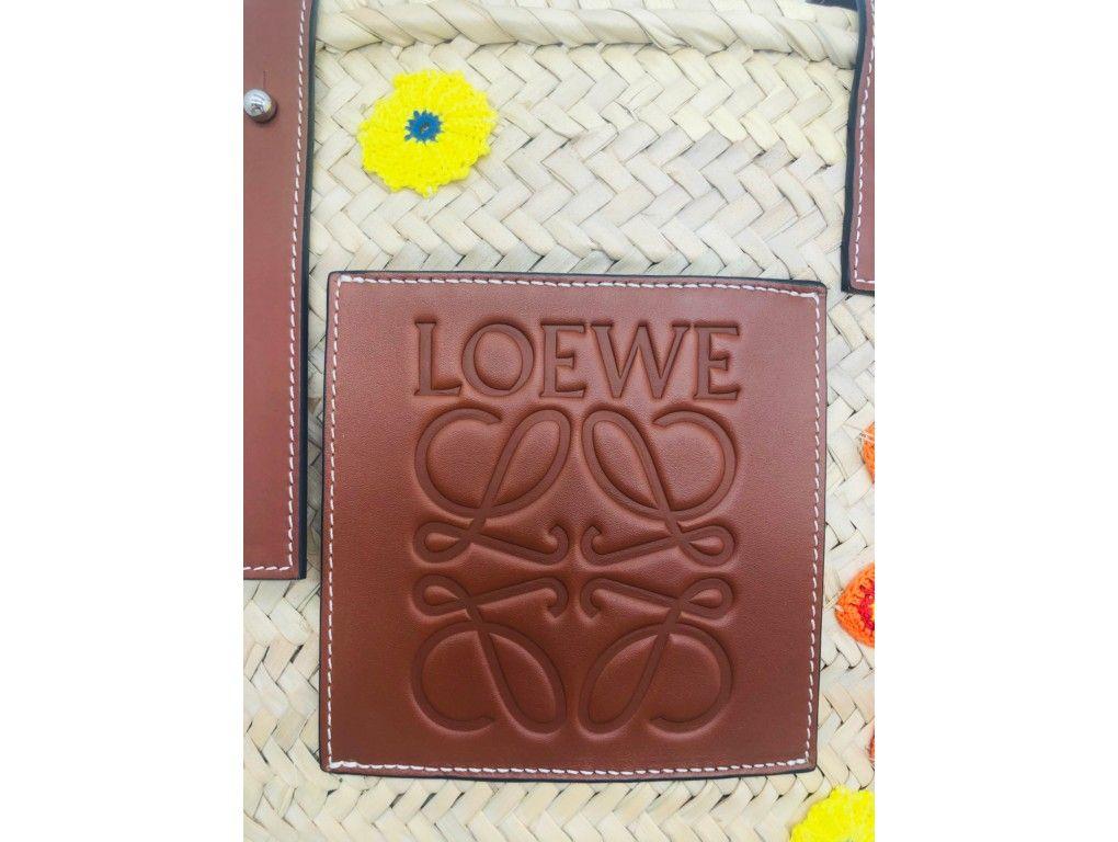 Such a fun tote bag by Loewe with it’s signature logo on the front in leather. A new piece, purchased, stored and never used.

BRAND	
Loewe

FEATURES	
Adjustable leather straps, handwoven palm leaf, orange yellow blue and green hand crocheted cotton