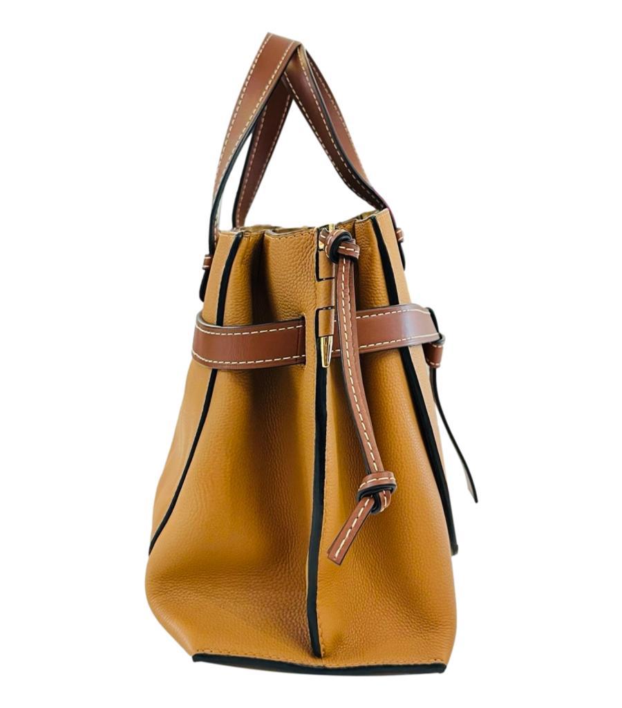Loewe Gate Leather Tote Bag
Caramel brown handbag designed with dark brown leather knot detailing to the centre.
Detailed with Loewe logo debossed to the top right corner, and dual top handle with adjustable, detachable shoulder strap.
Featuring