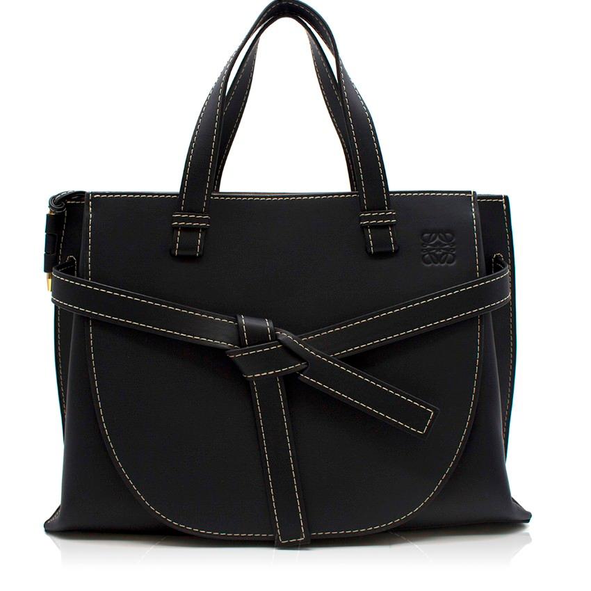 Loewe Gate leather tote bag

- Midnight-blue, smooth calf leather 
- Two top handles, detachable leather shoulder strap 
- Contrasting white stitching
- Signature knotted front belt bow and gold-tone Gate side pin
- Logo debossed front 
- Protective
