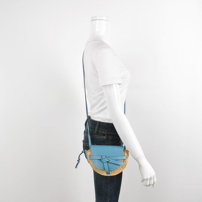 Loewe Gate Mini Blue Leather and Straw Crossbody Bag
These are professional photos of the actual bag.
  
  The Loewe Gate Mini Tan Brown Crossbody Bag exemplifies the brand's superior leather techniques, featuring a saddle-stitched knotted strap and