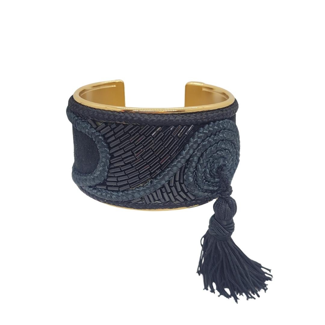 Etonnant et unique bracelet vintage en métal doré et garnitures de soie avec paillettes noires affichant des motifs de style oriental, terminé par un pompon en fil de soie noir, de la prestigieuse maison espagnole LOEWE, signé.
Pièce unique et