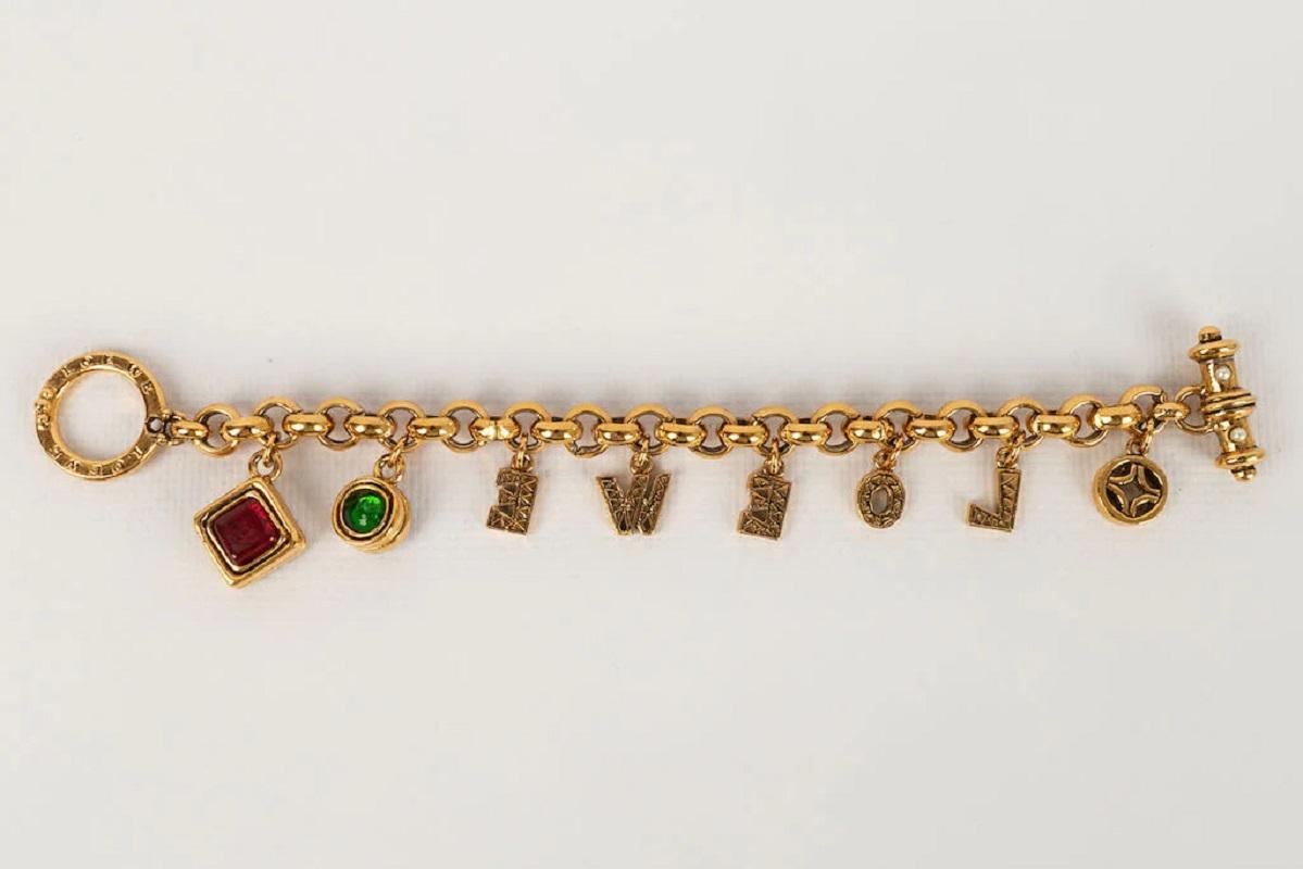 Loewe -Golden metal bracelet decorated with charms and glass paste. Jewel from the 1990s.

Additional information:
Dimensions: 19 L cm
Condition: Very good condition
Seller Ref number: BRA128