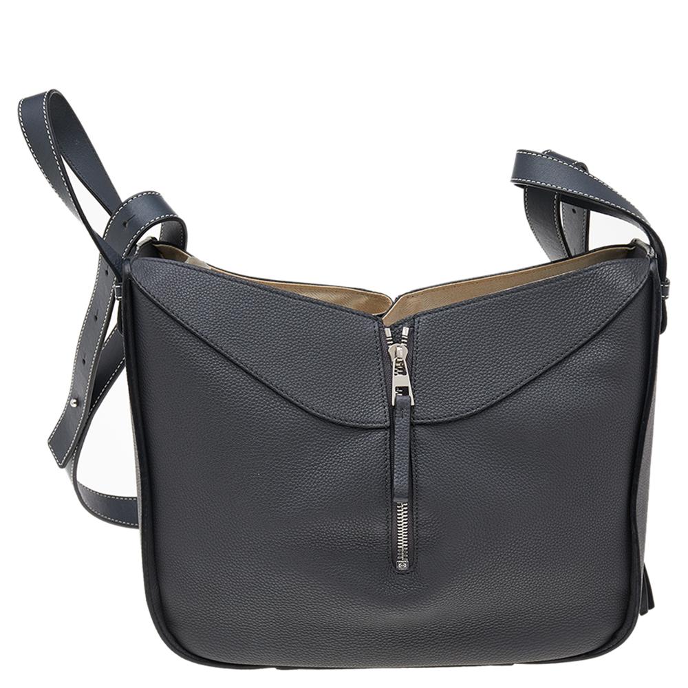 Loewe is known for its unique designs and quality craftsmanship. This grey bag is crafted from leather and neatly detailed with zip detailing. It has a spacious fabric-lined interior, capable of storing all your daily essentials. It is complete with
