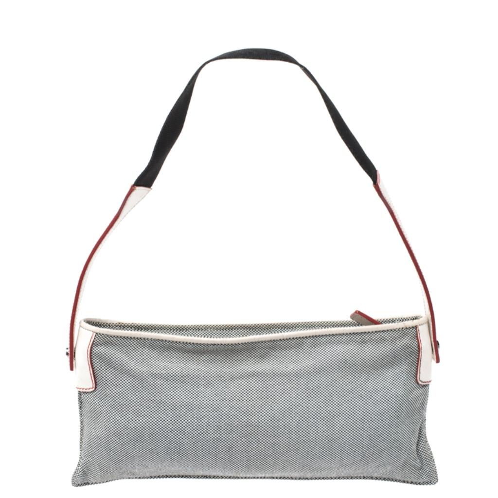 This gorgeous shoulder handbag by Loewe makes for a great buy. Crafted from quality canvas and leather, it flaunts lovely grey and white hues. It is held by a single handle and has a zip closure that opens to reveal a canvas-lined interior. It can